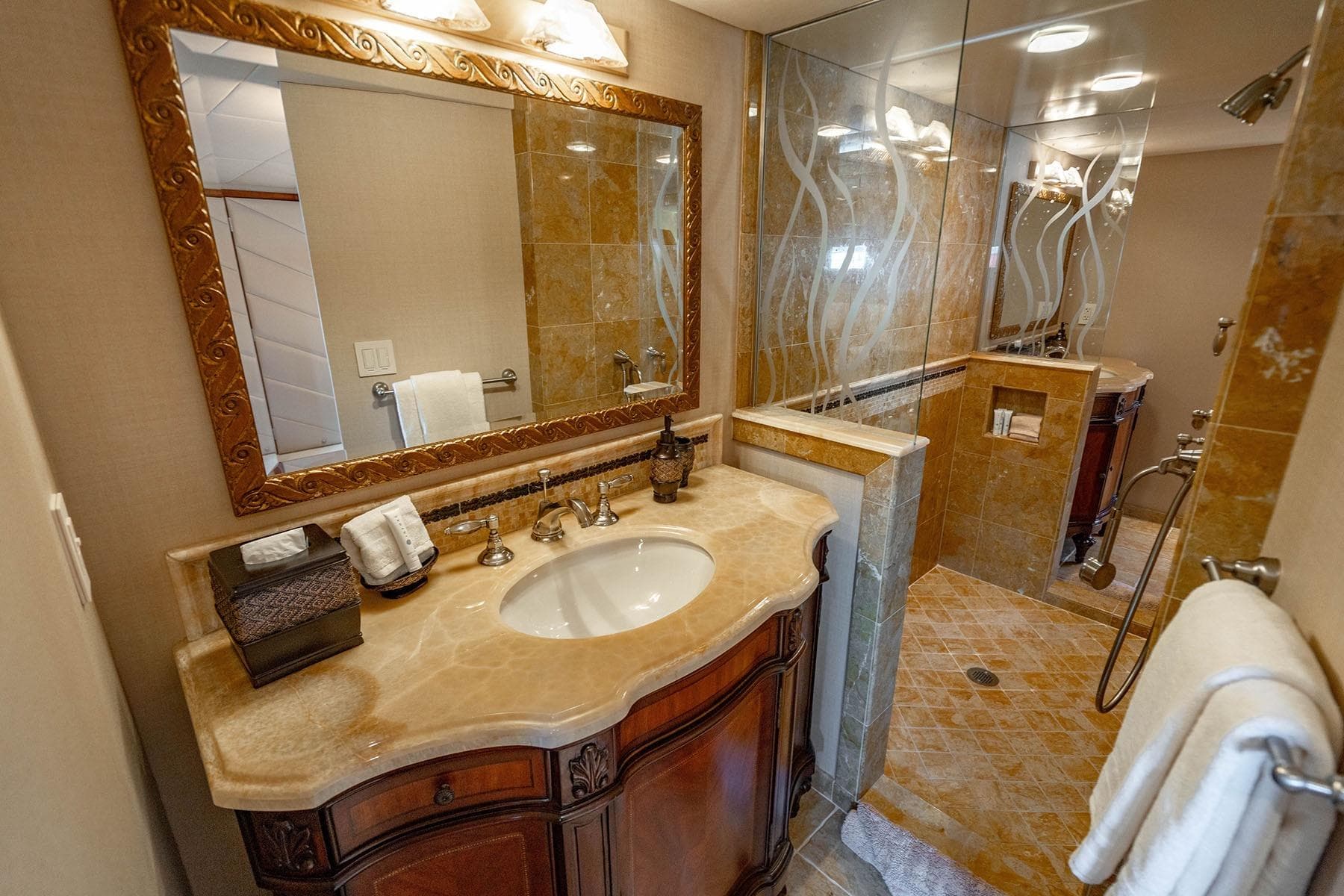 Luxurious bathroom on 2009 Custom Crystal Motoryacht with elegant marble sink and glass shower.