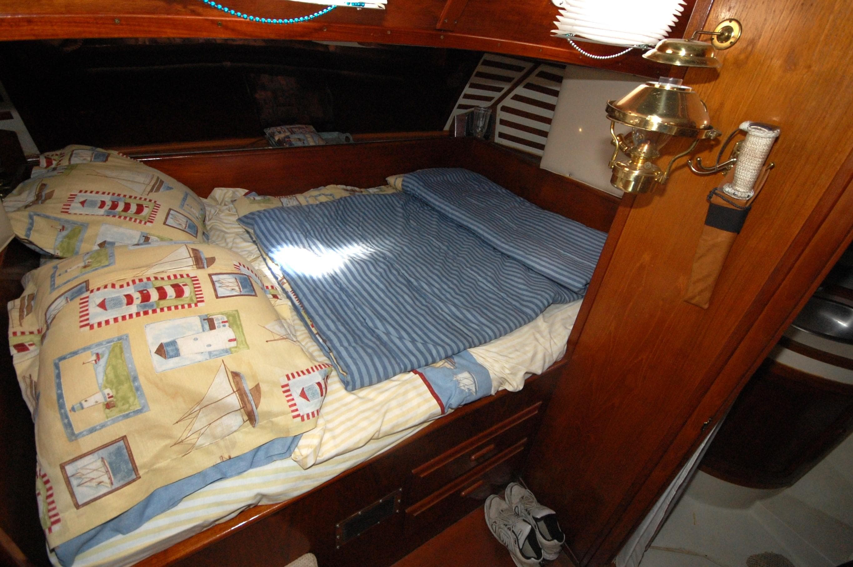 Cozy cabin interior of 1981 Endeavour 40 sailboat with nautical-themed bedding.