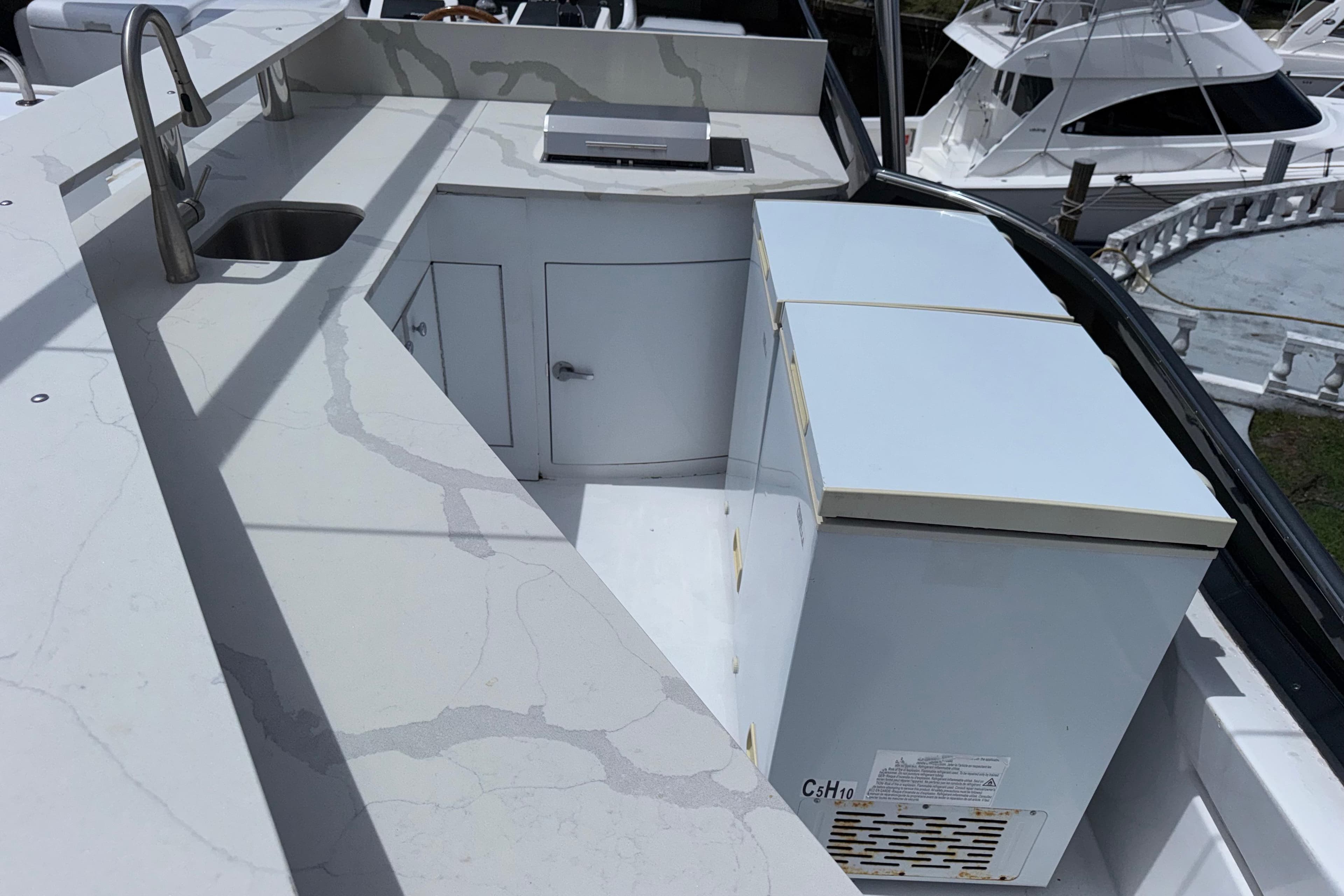 Outdoor kitchen area on a 1998 Azimut 85 Ultimate yacht, featuring a sink and storage.