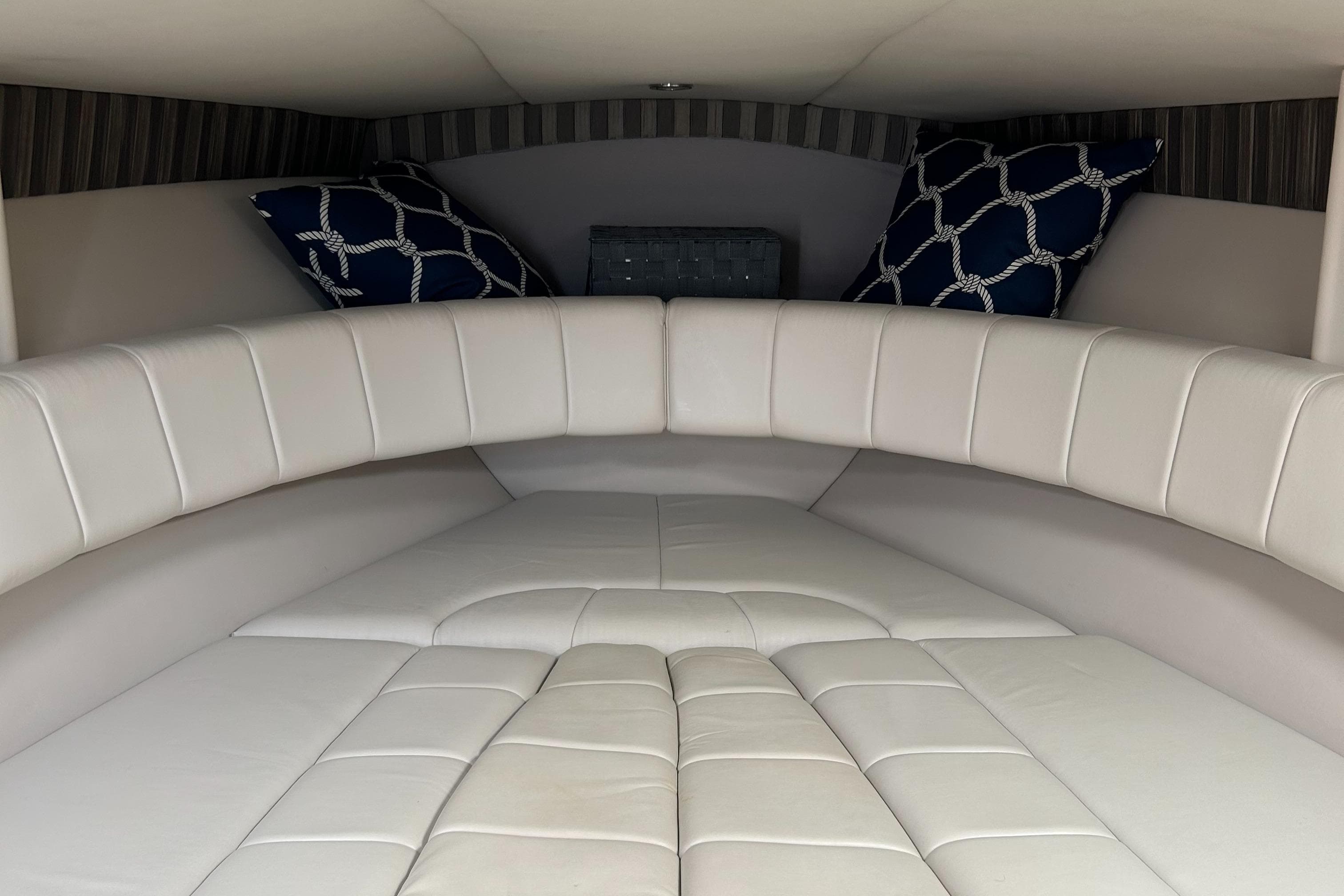 2005 Formula 330 Sun Sport cabin interior with white leather seating and decorative pillows.