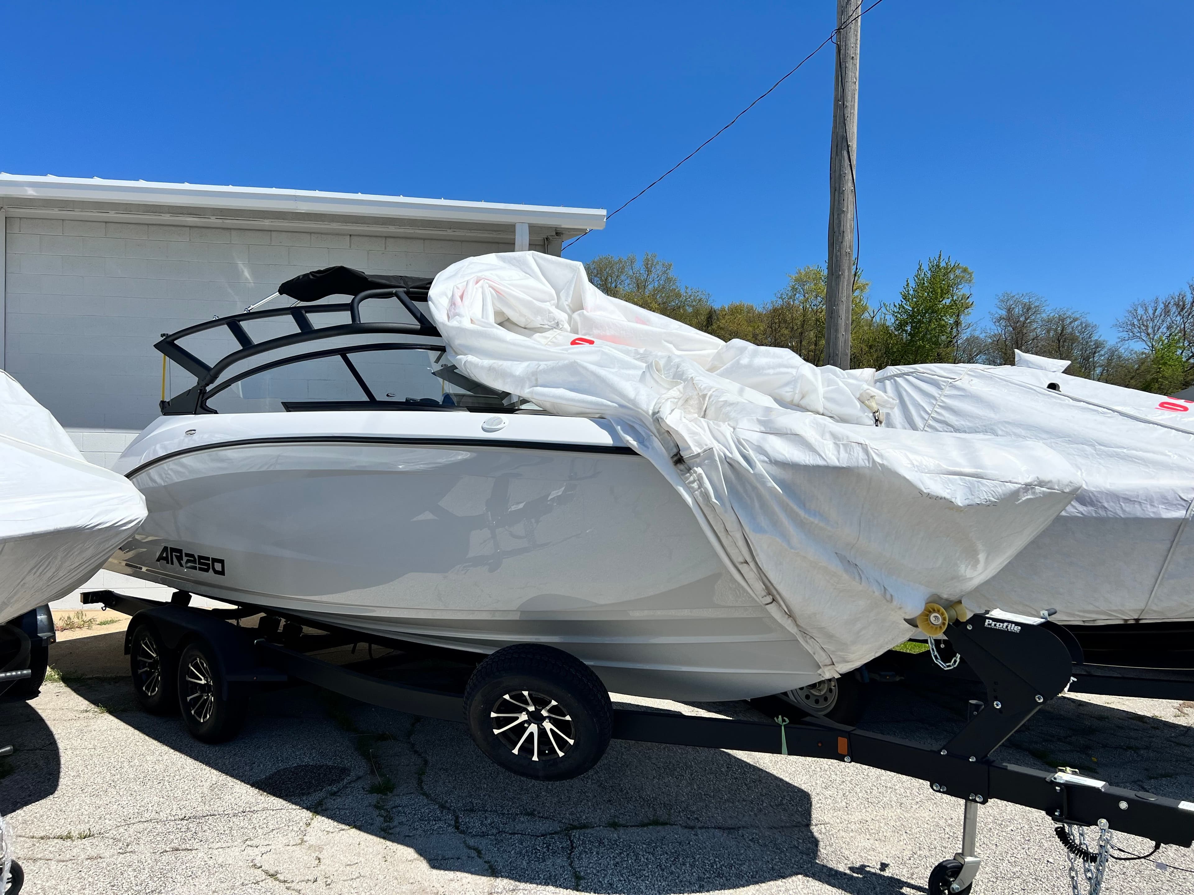 2025 Yamaha AR250 boat on trailer, partially covered.
