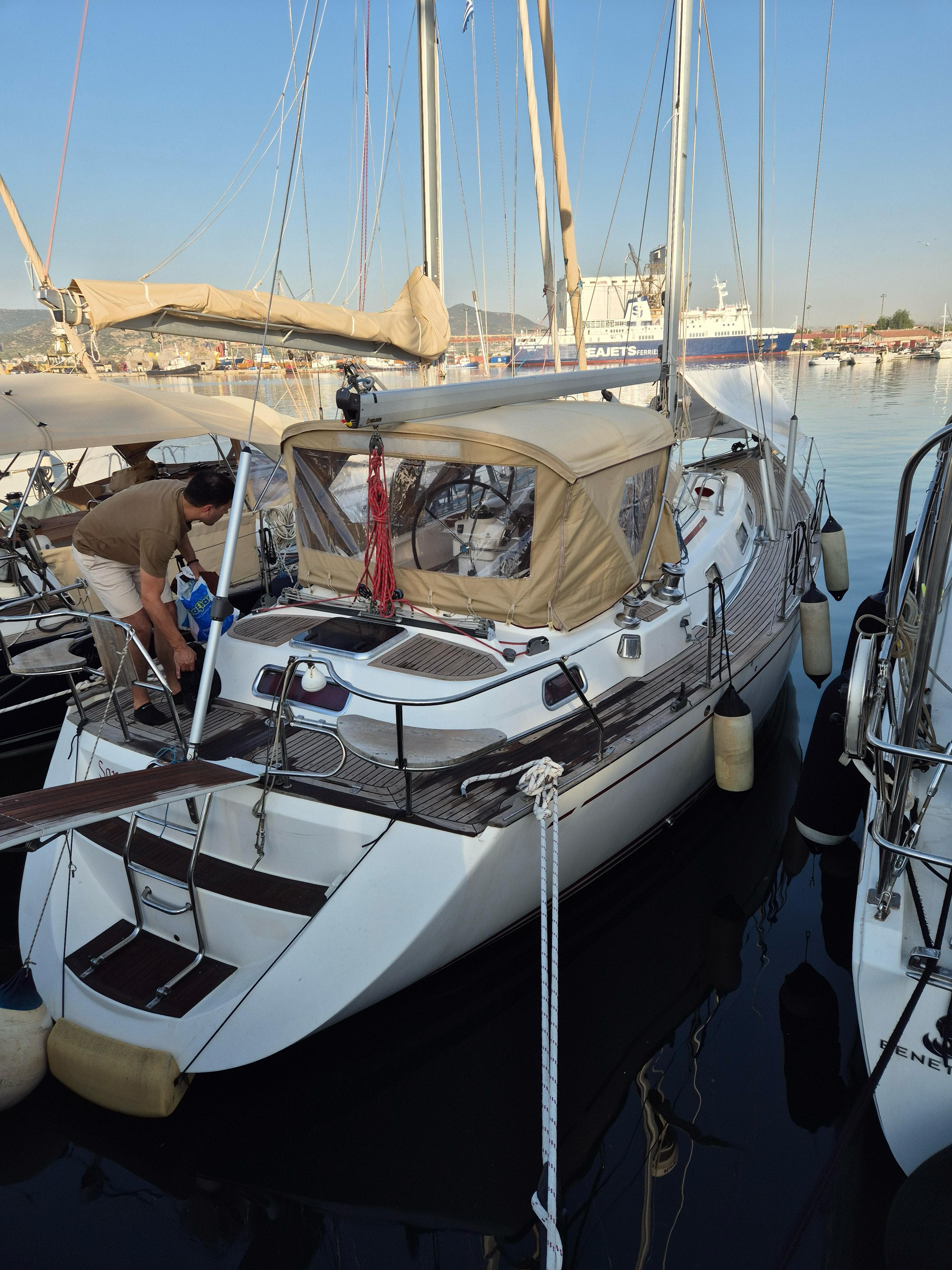 2007 Najad 380 sailboat docked in marina, featuring beige canopy and wooden deck.