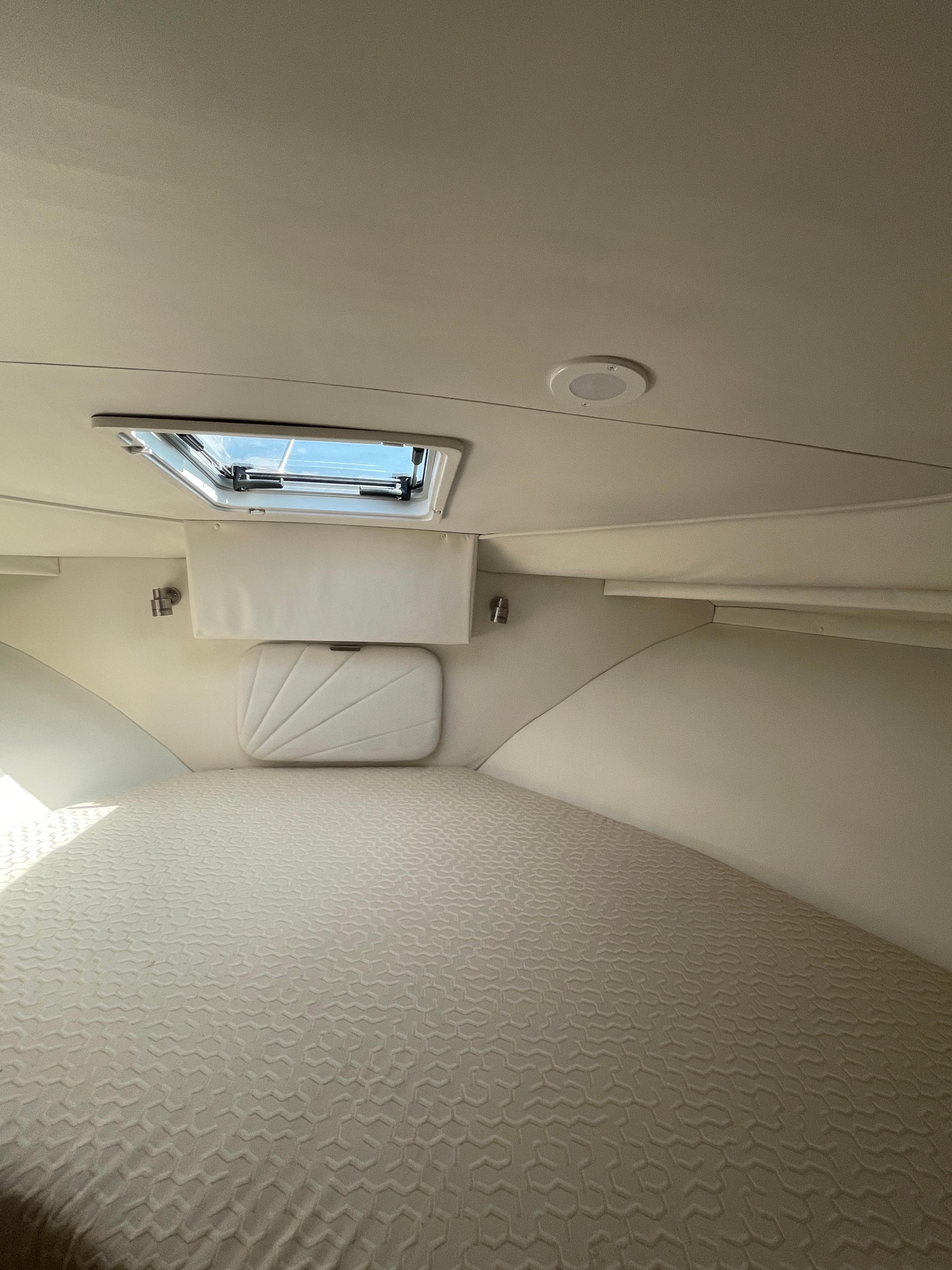 Interior cabin of a 1997 Carver 405 yacht with a bed and ceiling hatch.