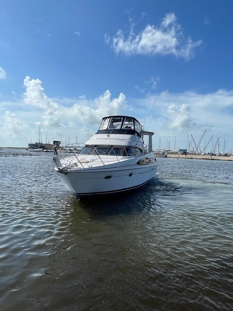 2001 Carver 444 Cockpit Motor Yacht on calm water under blue sky.