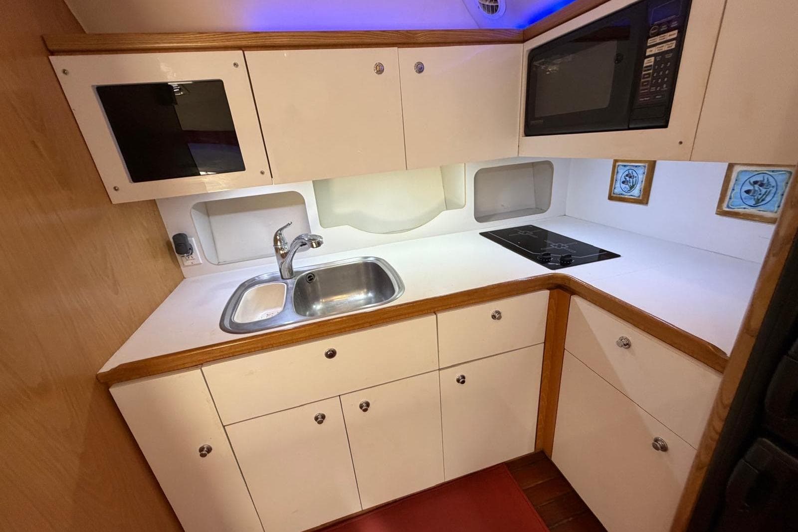 1999 Tiara Yachts 4100 Open galley with sink, stove, and microwave.