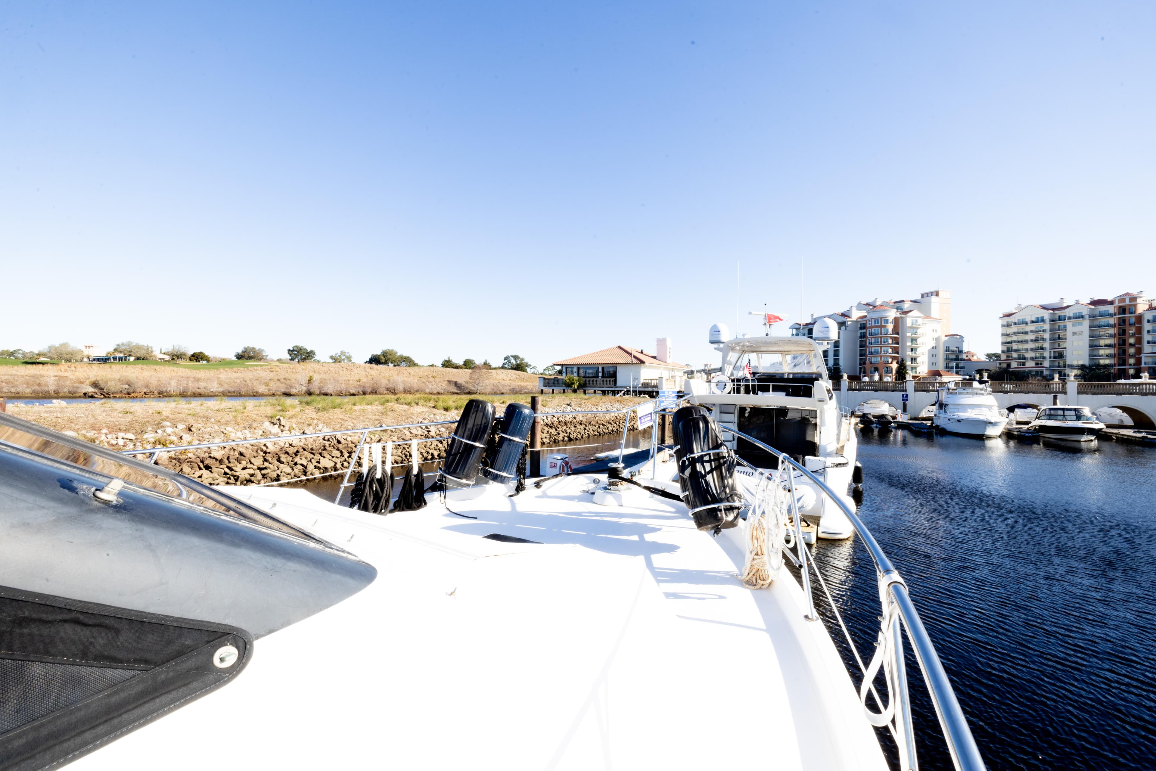 1989 Viking 63 Motor Yacht docked in a marina with clear blue skies.