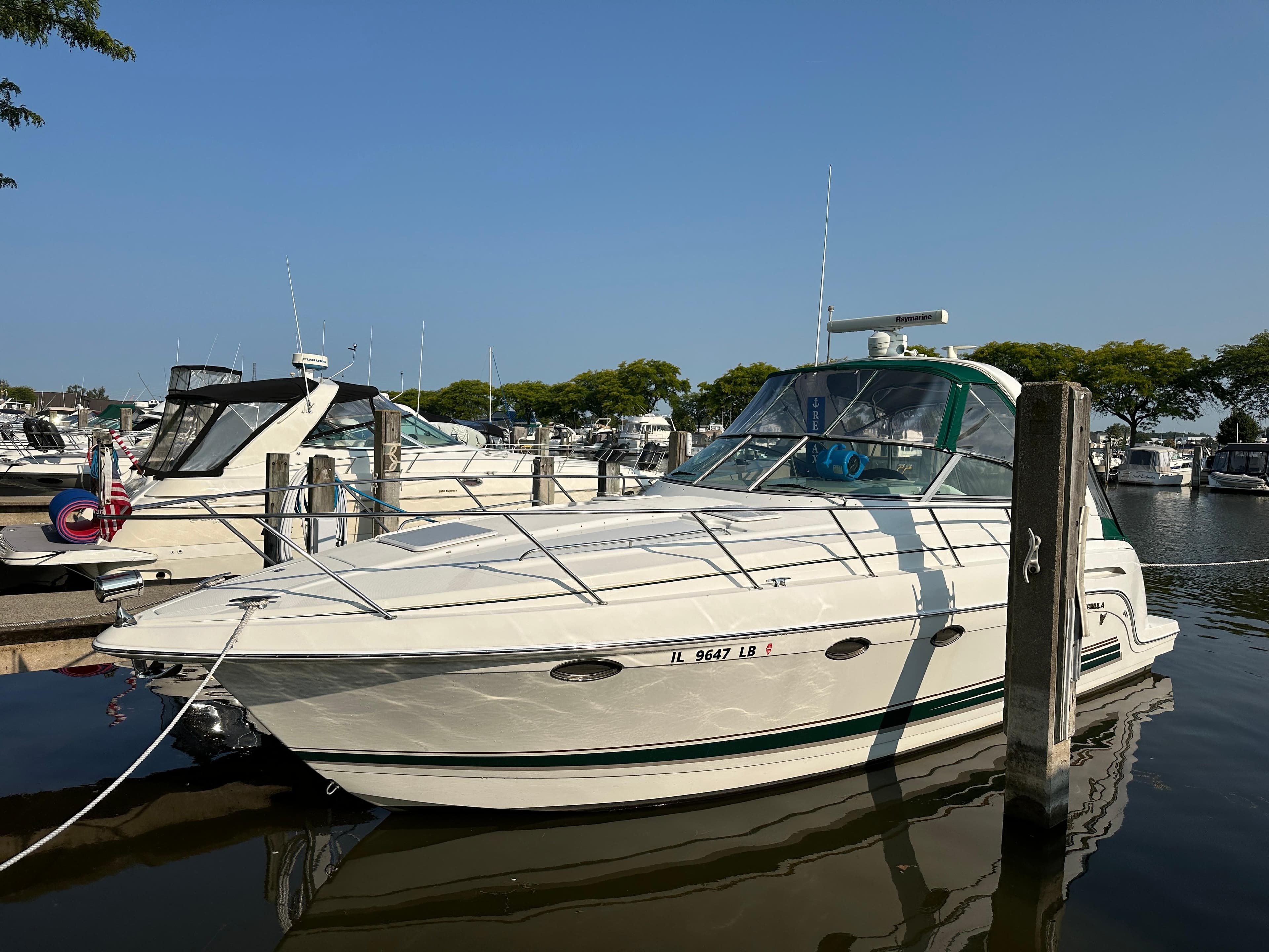 2004 Formula 34 PC boat docked in marina under clear blue sky.