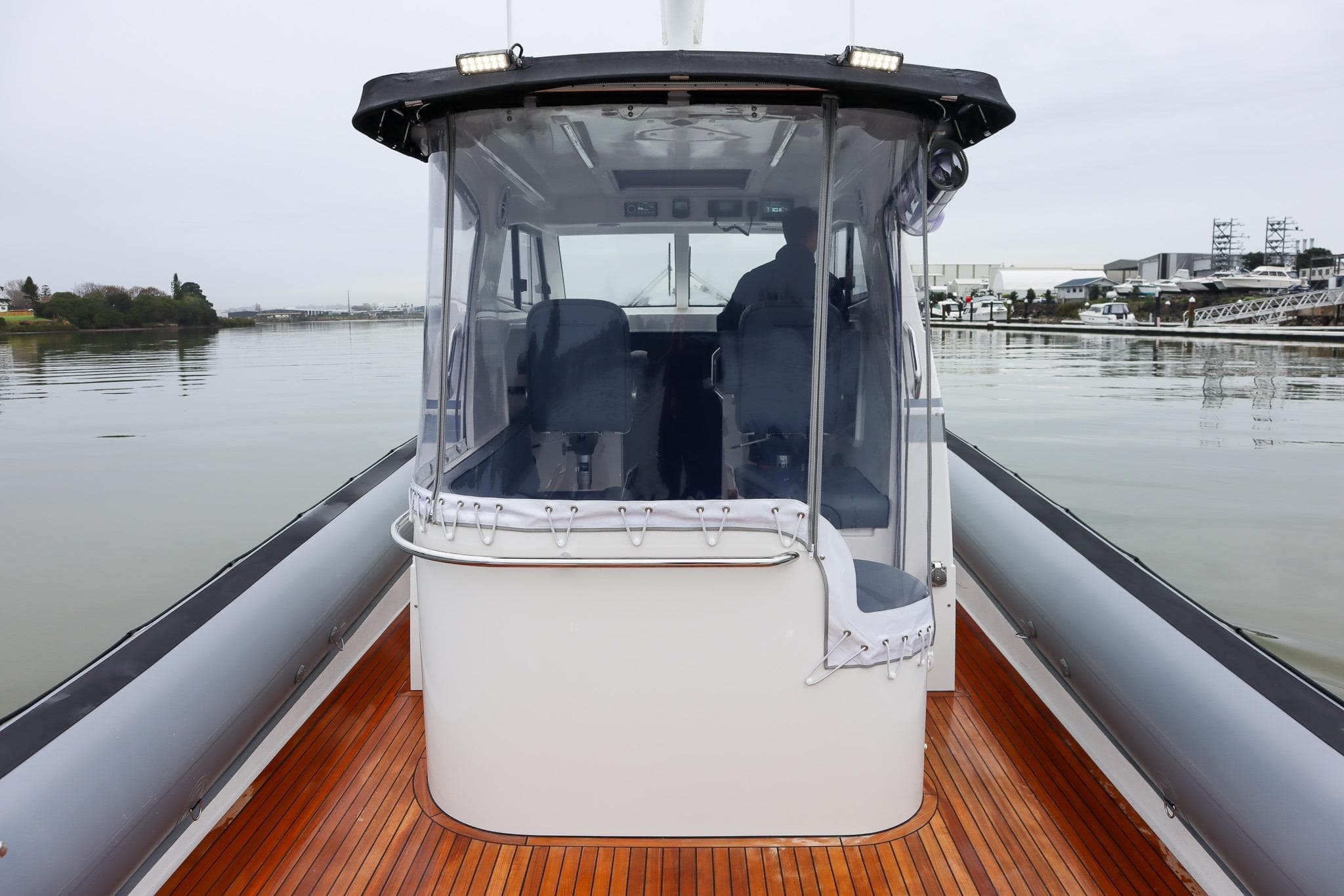 2022 Rayglass Protector 410 Targa boat on calm water, featuring sleek design and wooden deck.