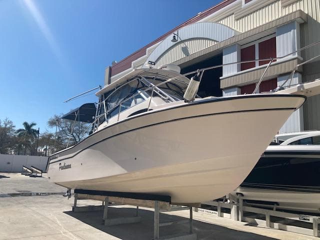 2003 Grady-White Marlin 300 boat on a stand outside a storage facility.