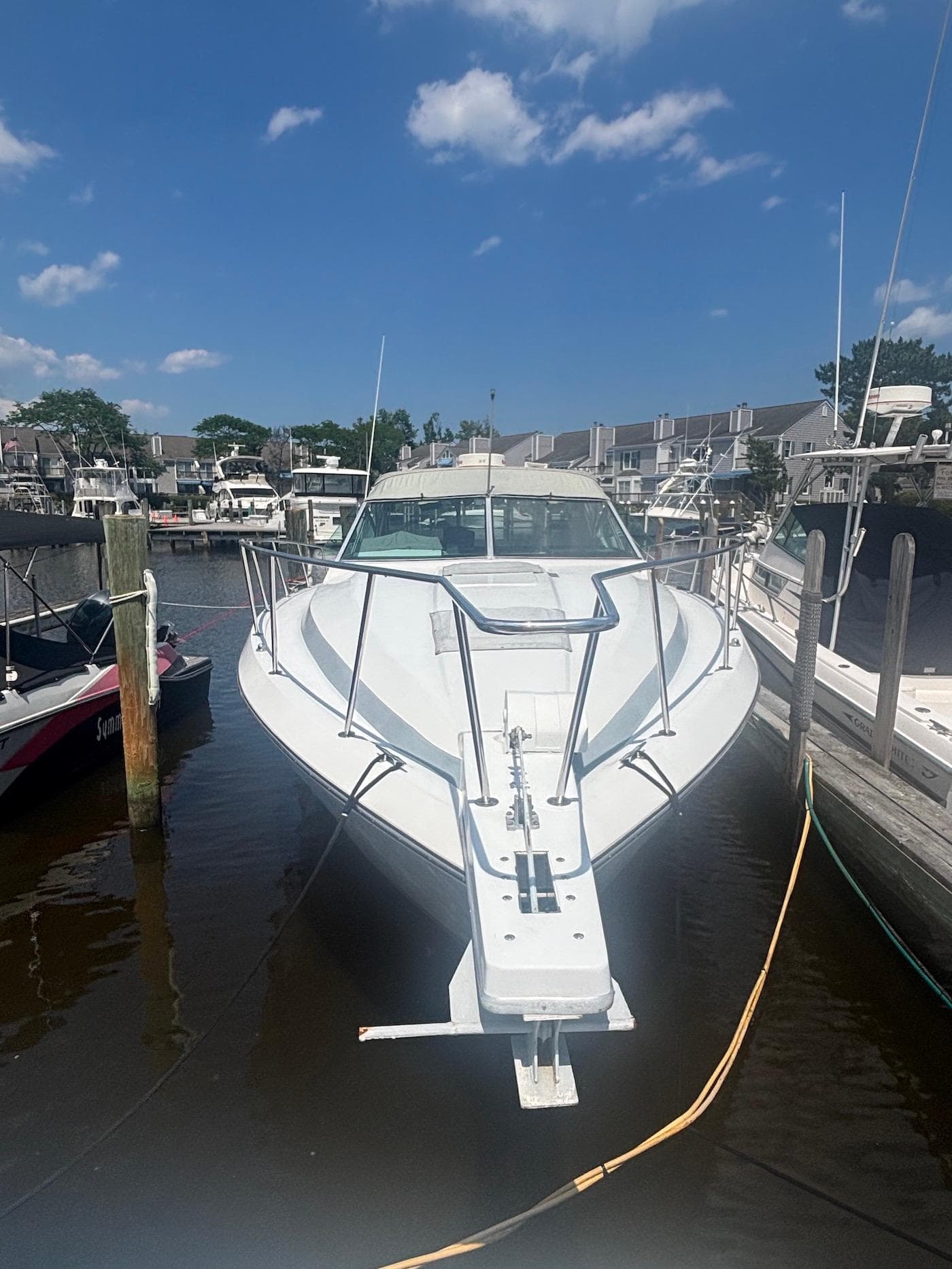 1987 Chris-Craft 336 Amerosport boat docked in marina under clear blue sky.