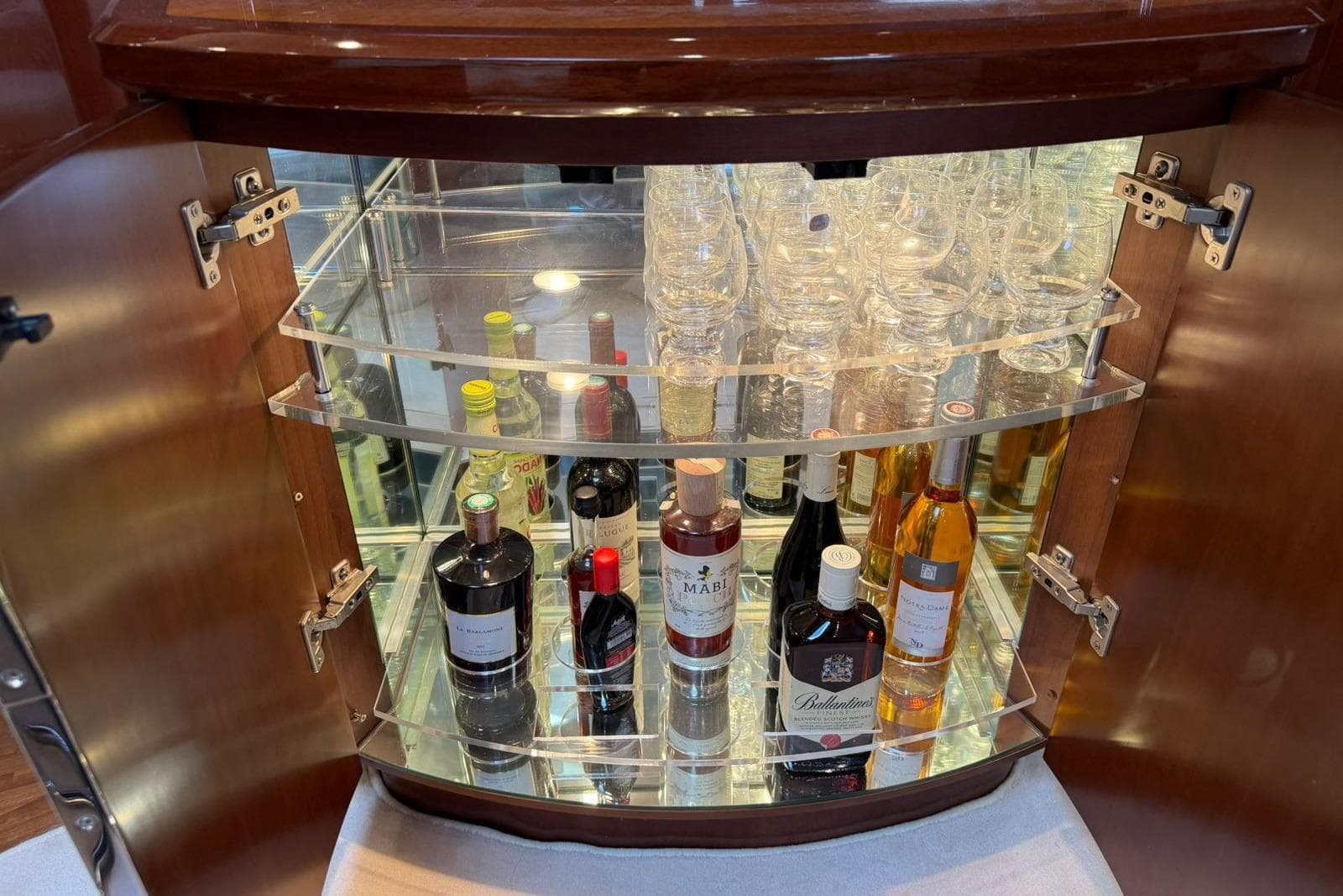 Bar cabinet with assorted liquor bottles and glasses on a Princess V58 yacht, 2003 model.