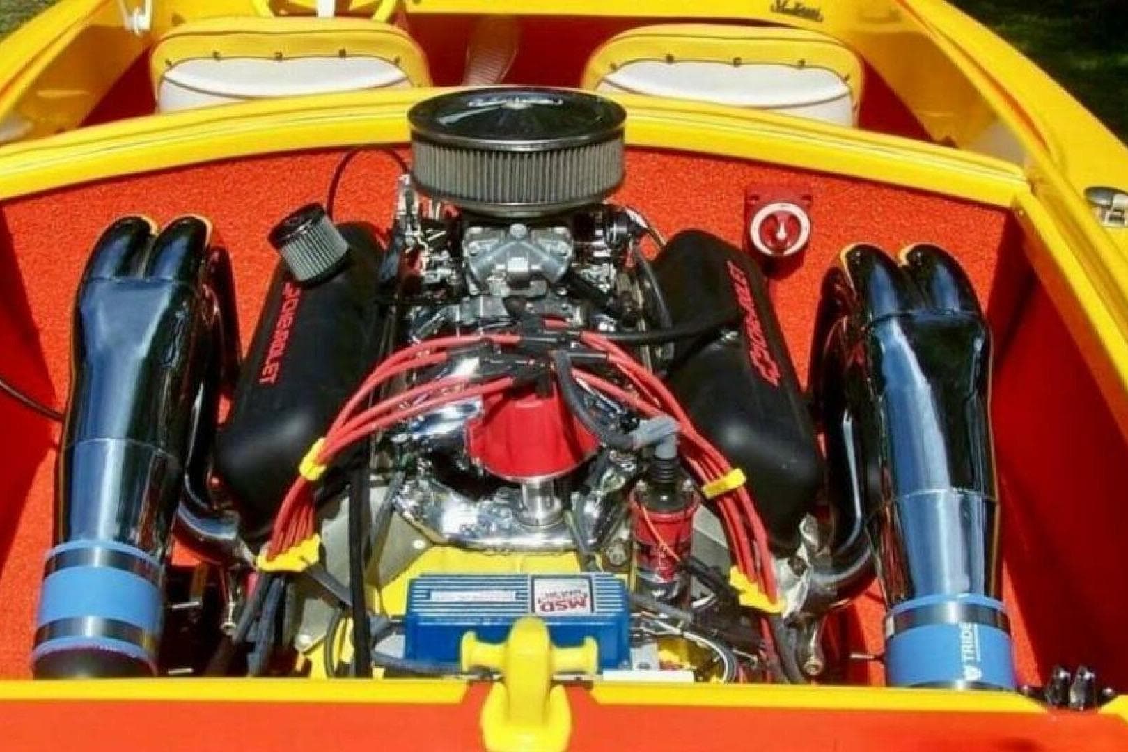 2009 Sleekcraft Kuaui boat engine with chrome headers and vibrant red accents.