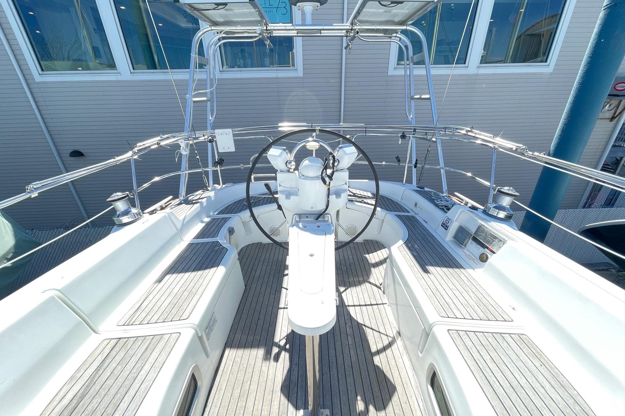 Cockpit view of 2004 Beneteau 423 sailboat with steering wheel and seating.