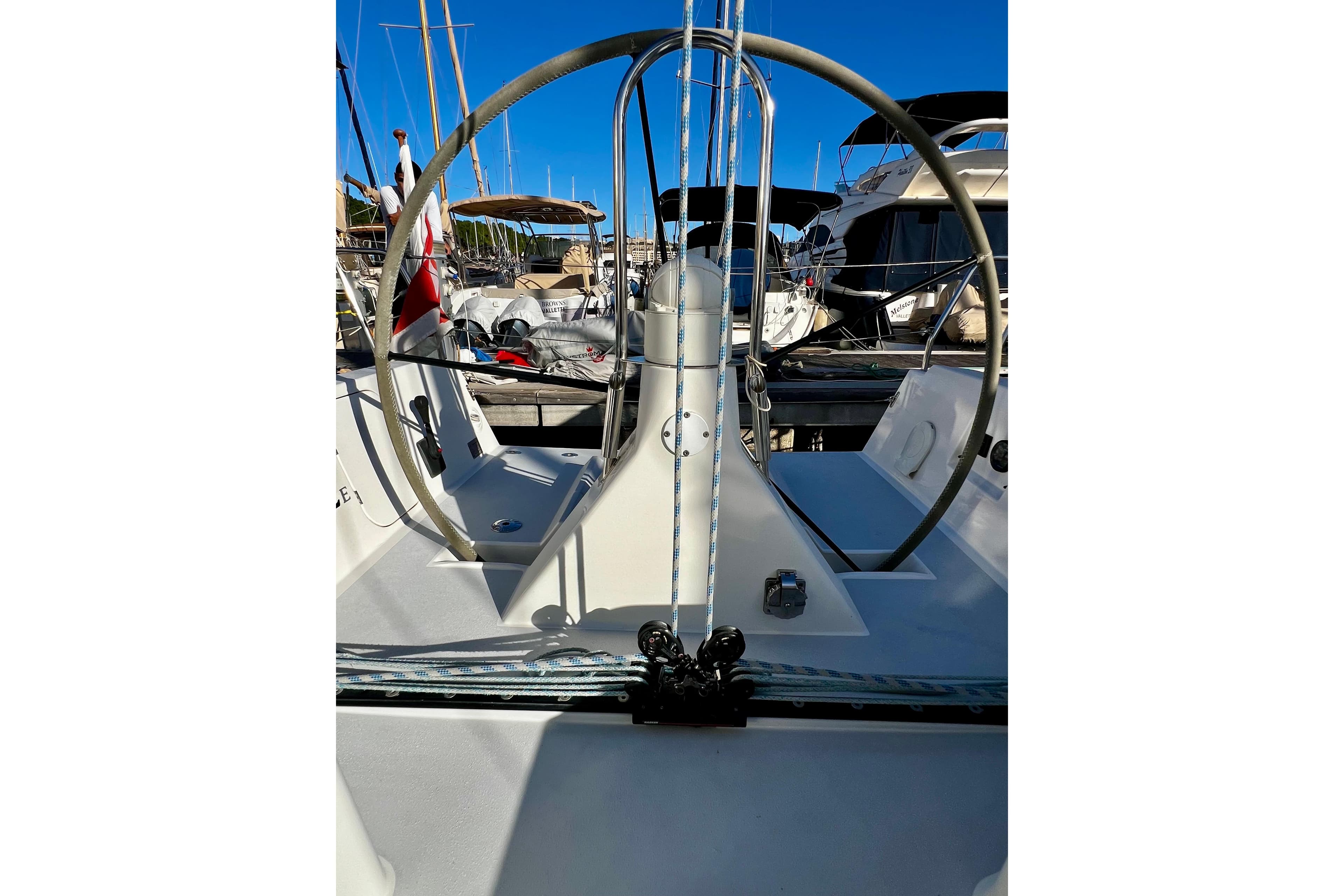 2018 J-Composites J/112E sailboat cockpit with steering wheel, docked in marina.