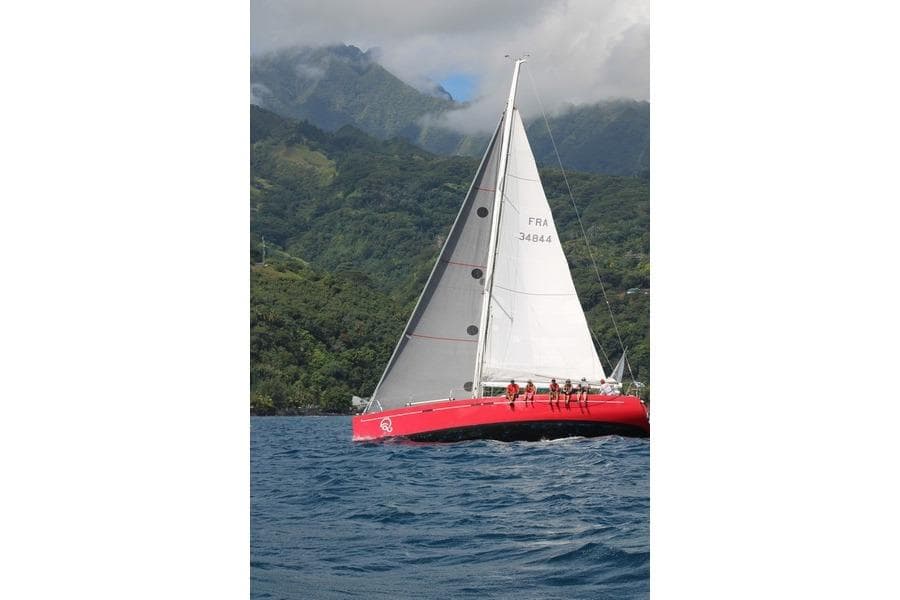 2008 Dehler 44 SQ sailboat navigating scenic waters with lush green mountains in the background.