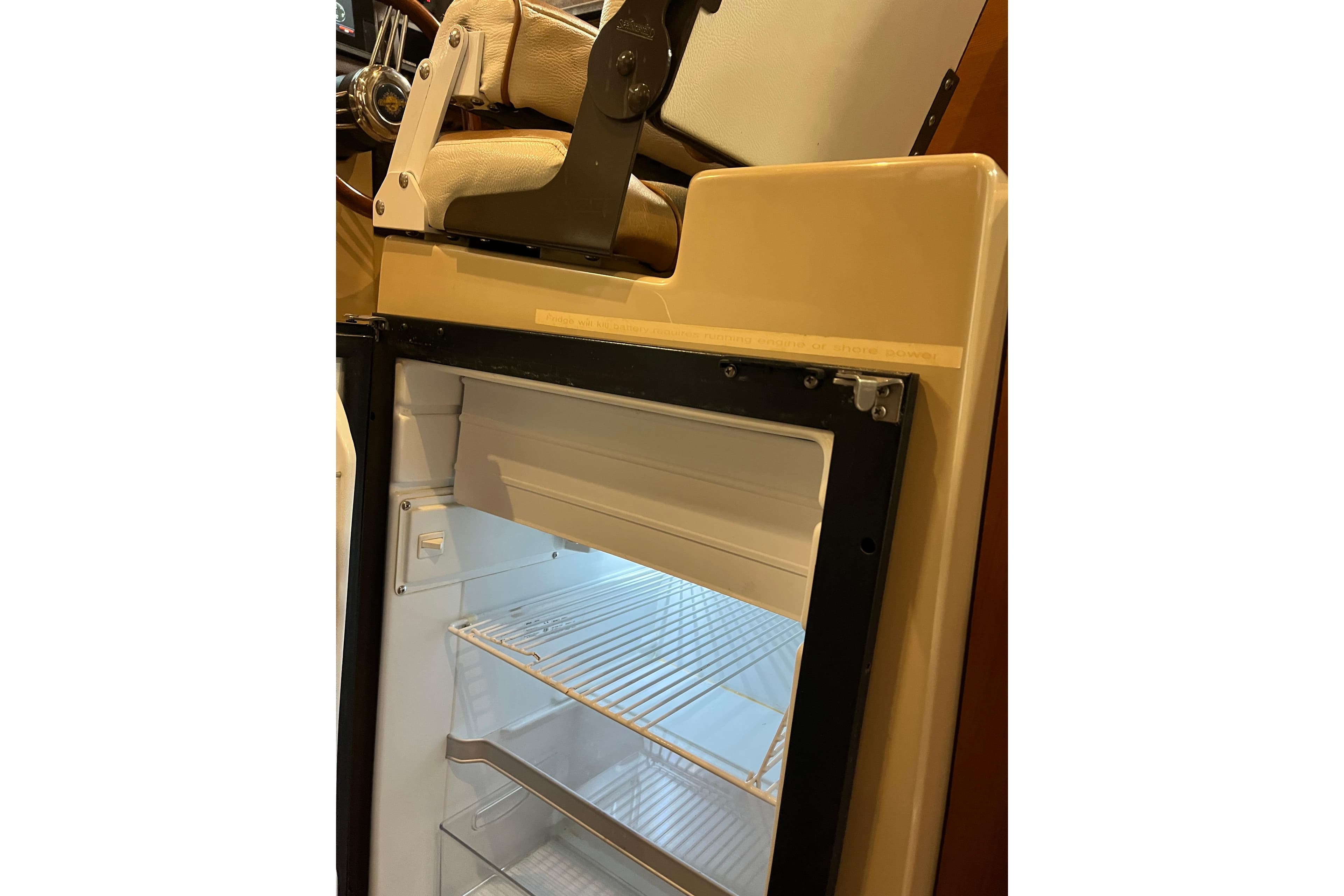 Open refrigerator inside 2017 Ranger Tugs R-23 boat, showcasing interior shelves.
