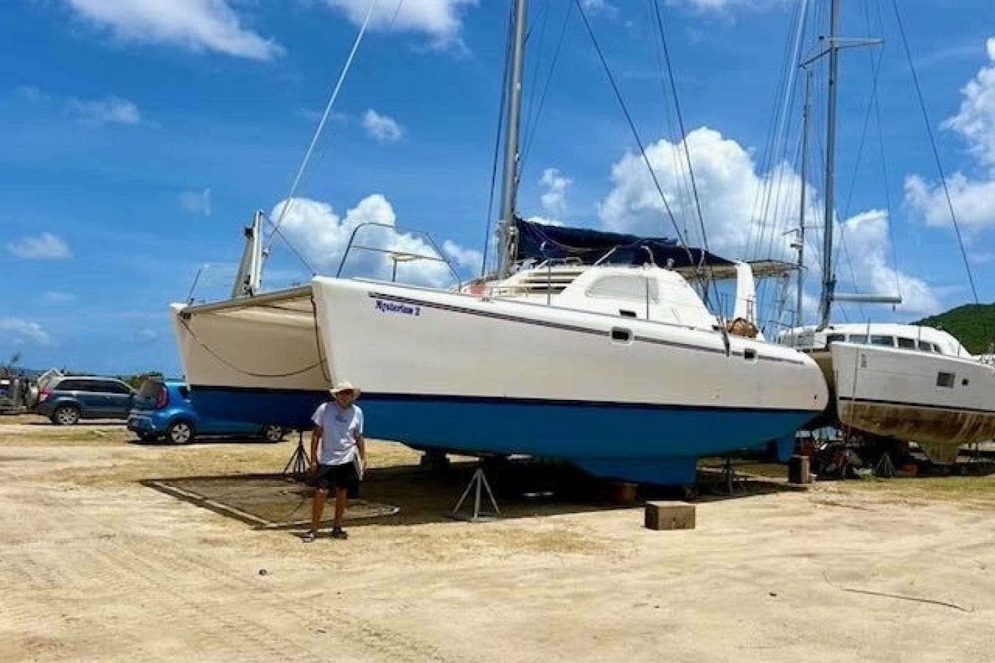 2001 Leopard 38 catamaran on land, clear sky, person standing nearby.