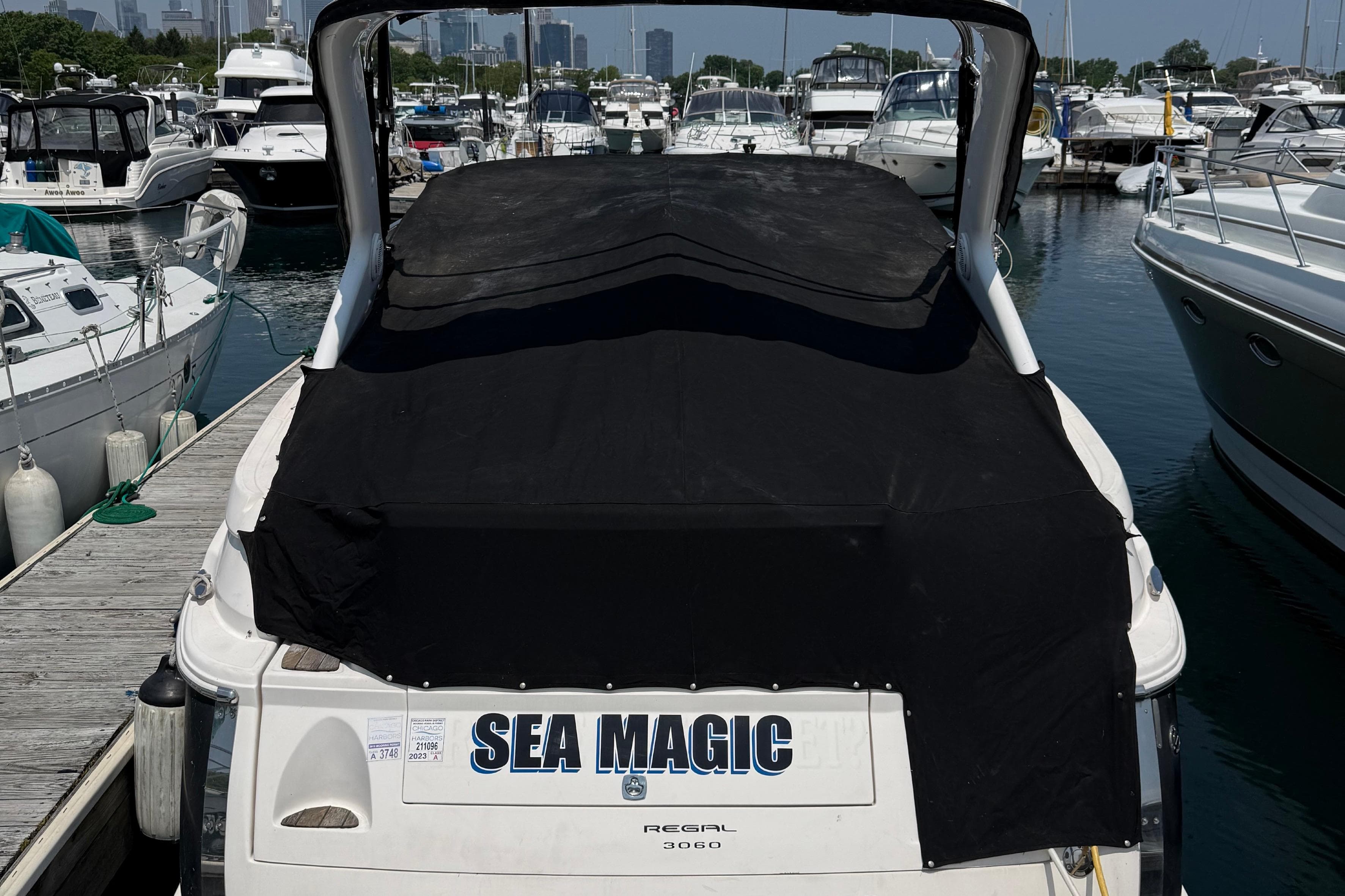 2007 Regal 3060 Window Express boat named "Sea Magic" docked at a marina.
