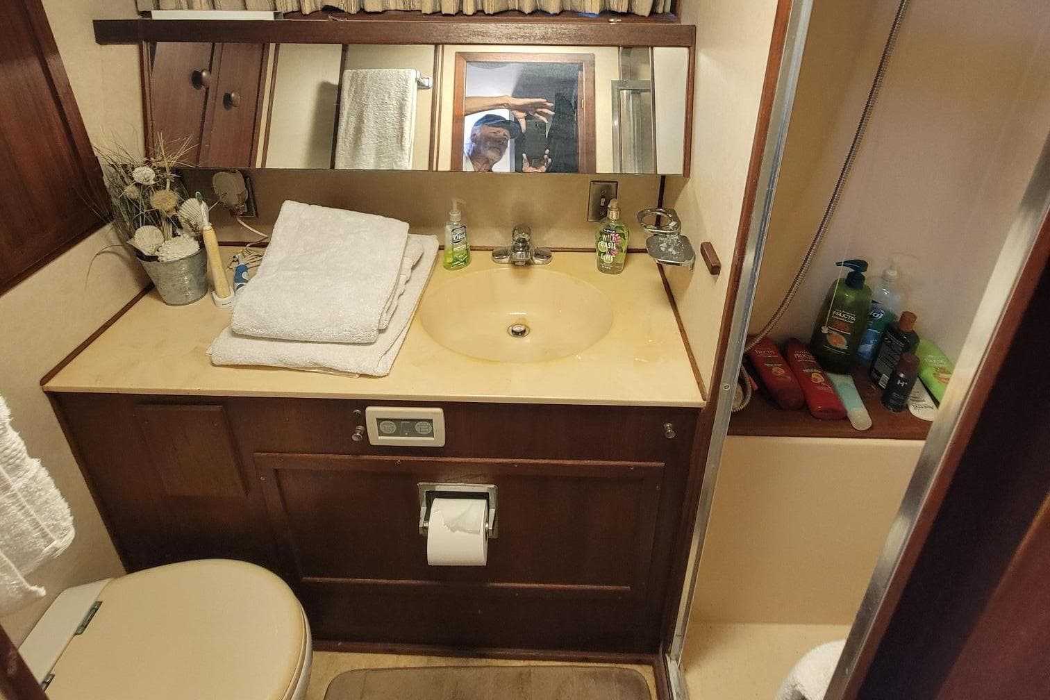 1985 Chris-Craft 500 Constellation bathroom with sink, toiletries, and towels.