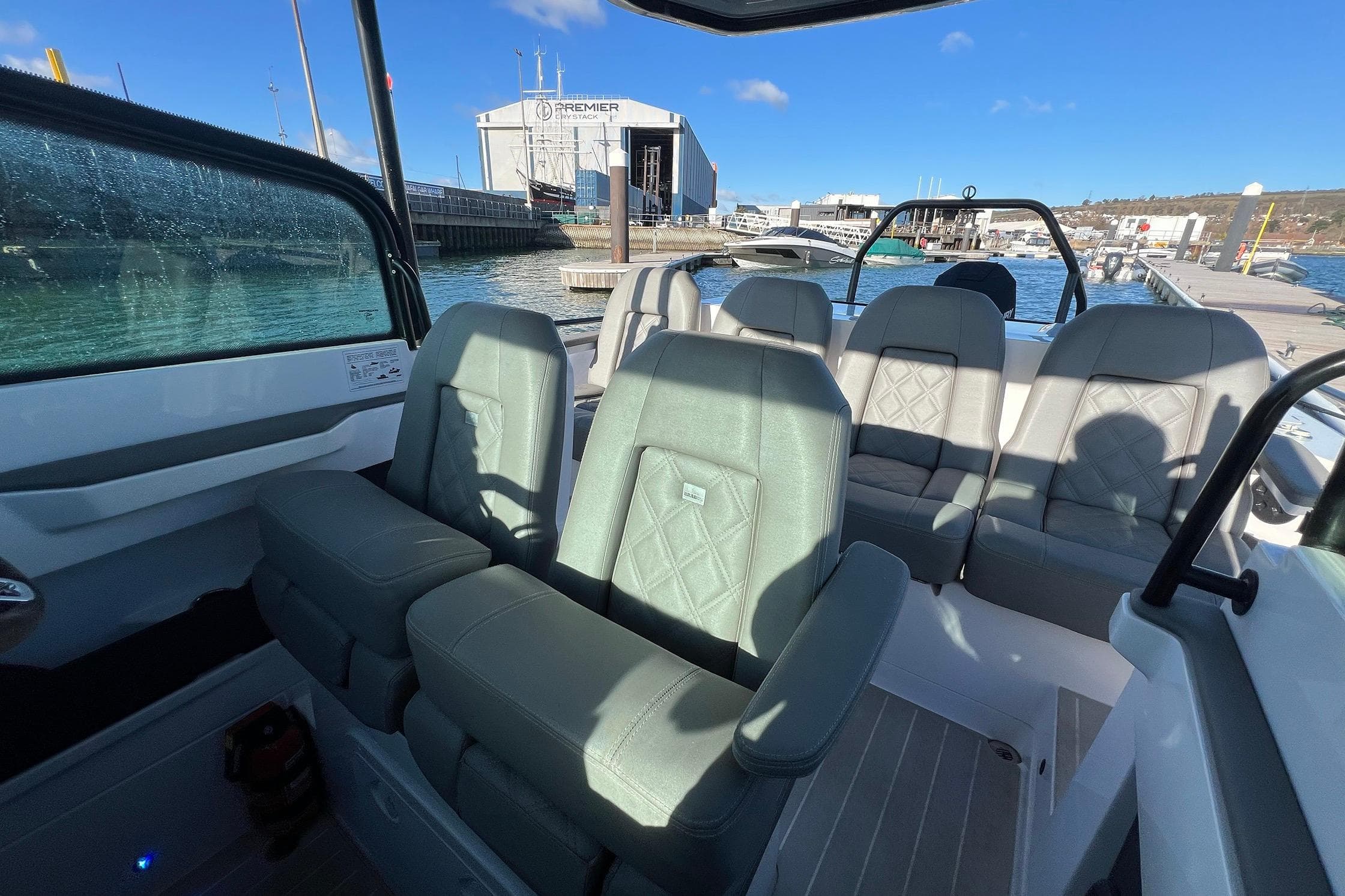 2019 Axopar 28 T-Top boat interior with stylish seating and waterfront view.