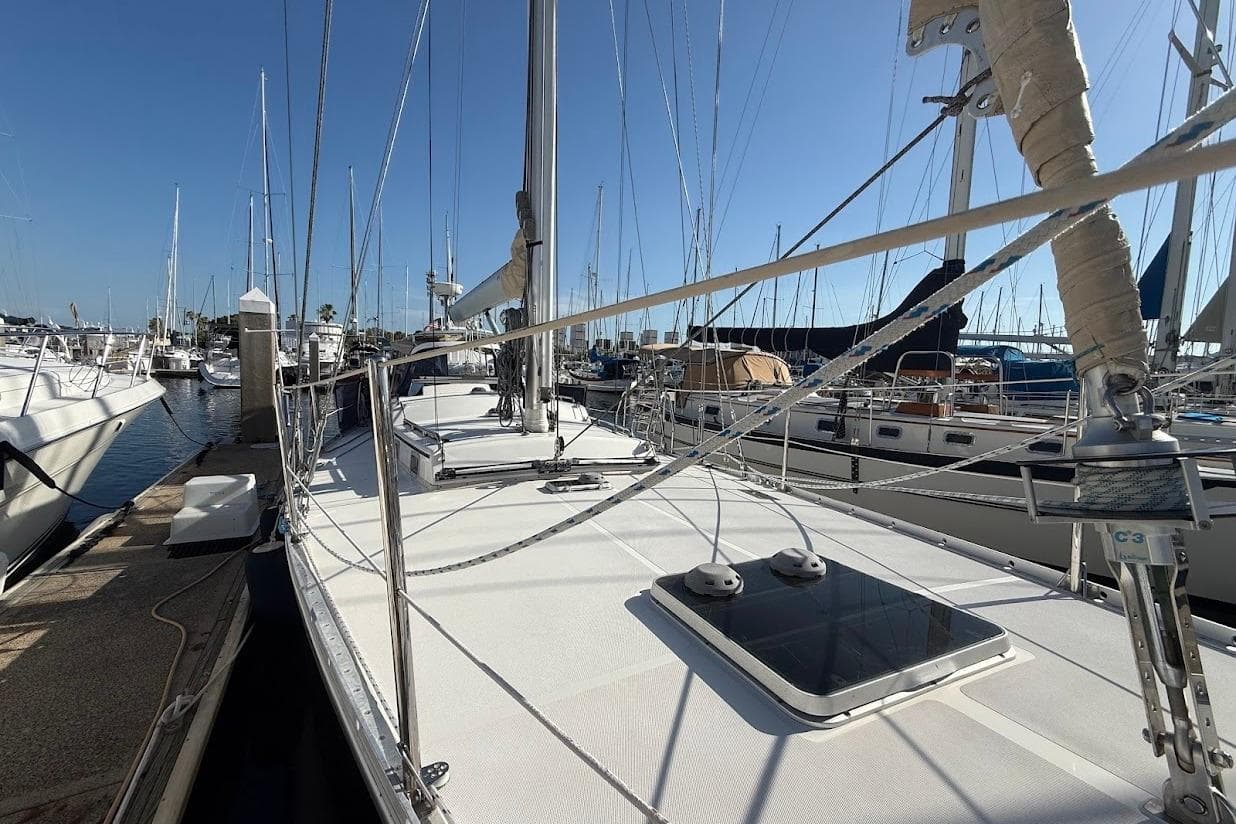 Sailboat docked at marina, Reliance 44 model, 2011, with clear blue sky.