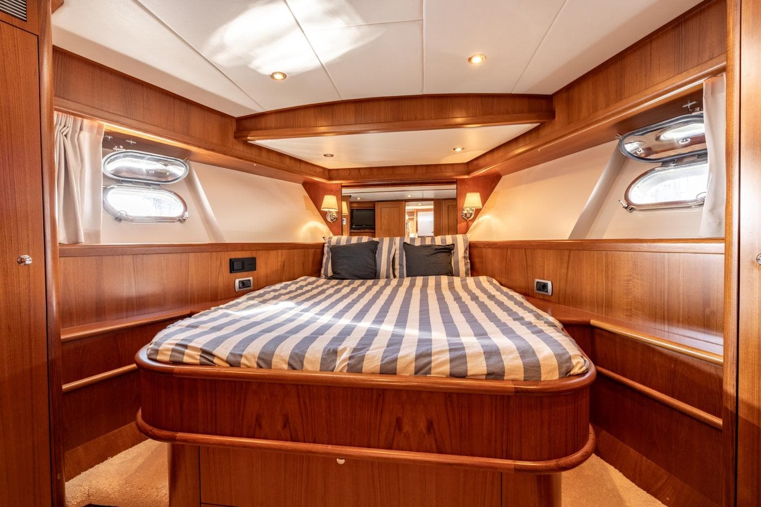 Luxurious cabin interior of 2009 Mulder 70 Wheelhouse yacht with striped bedding.