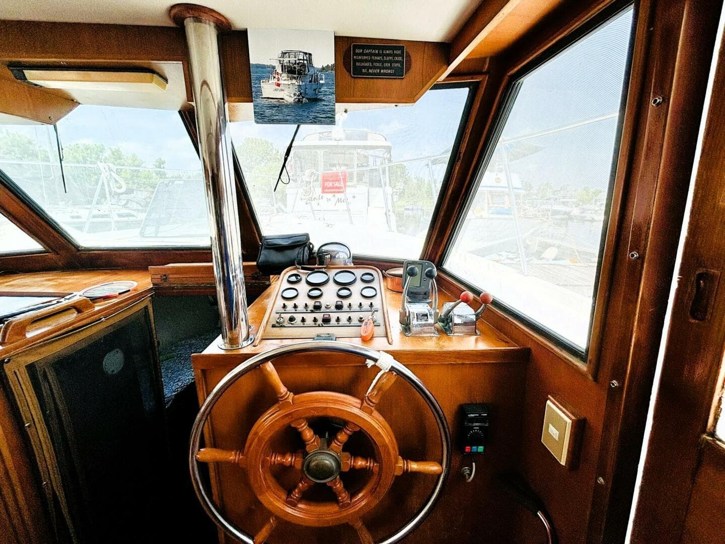 1985 DeFever 40 Offshore yacht helm with wooden wheel and control panel.