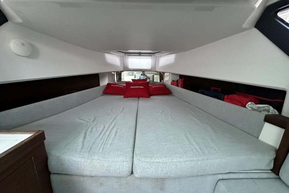 2019 Axopar 37 T-Top cabin interior with spacious bed and red cushions.