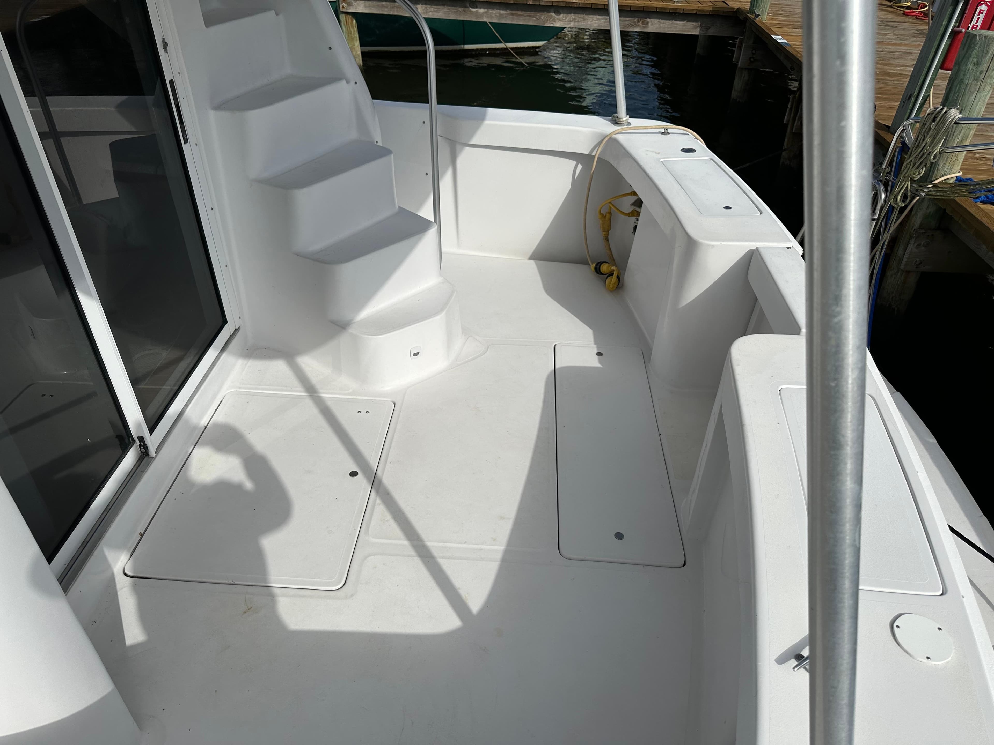 1998 Mainship 350 Trawler deck with white stairs and seating area.