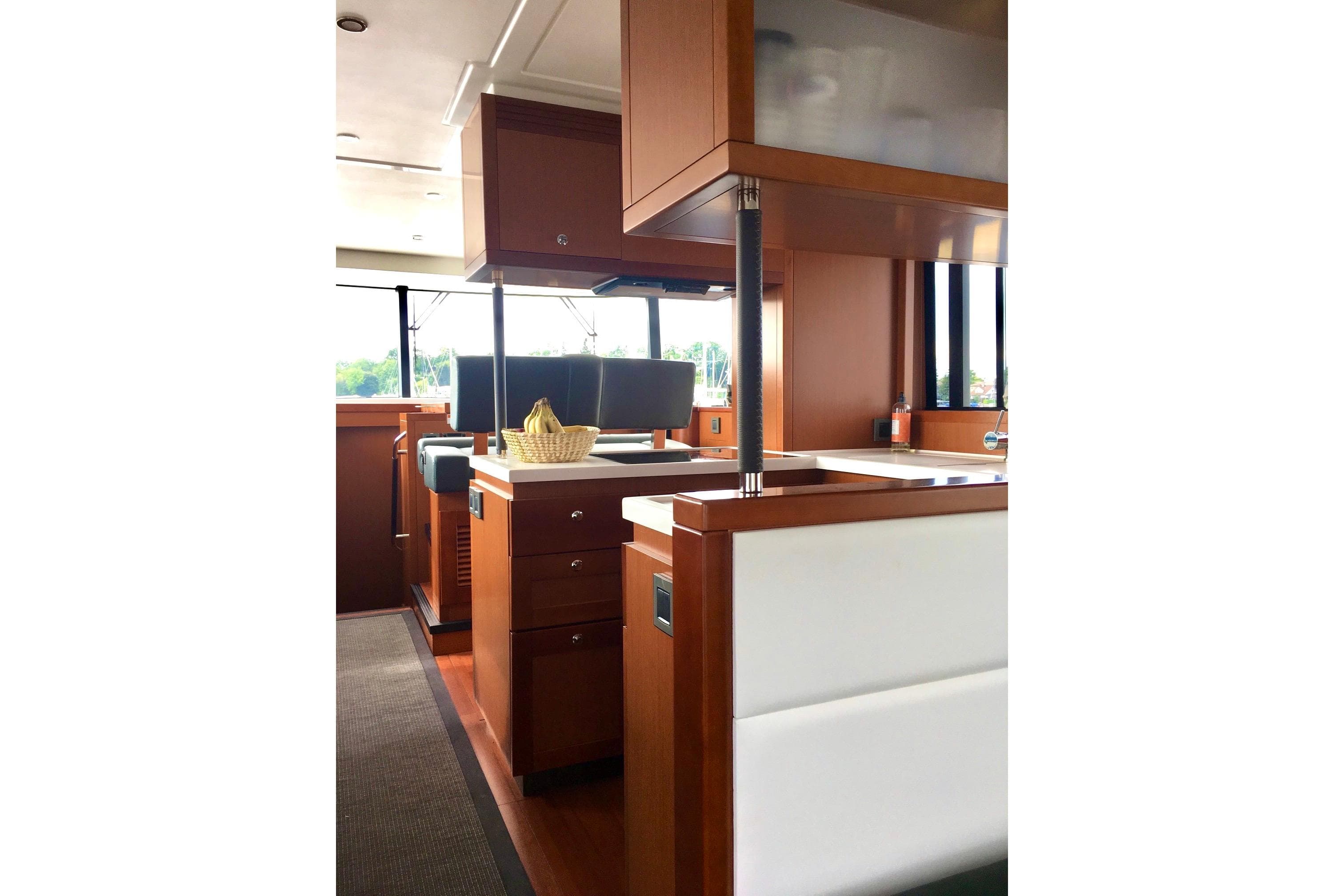 Interior of 2018 Beneteau Swift Trawler 50, featuring modern wood cabinetry and seating.