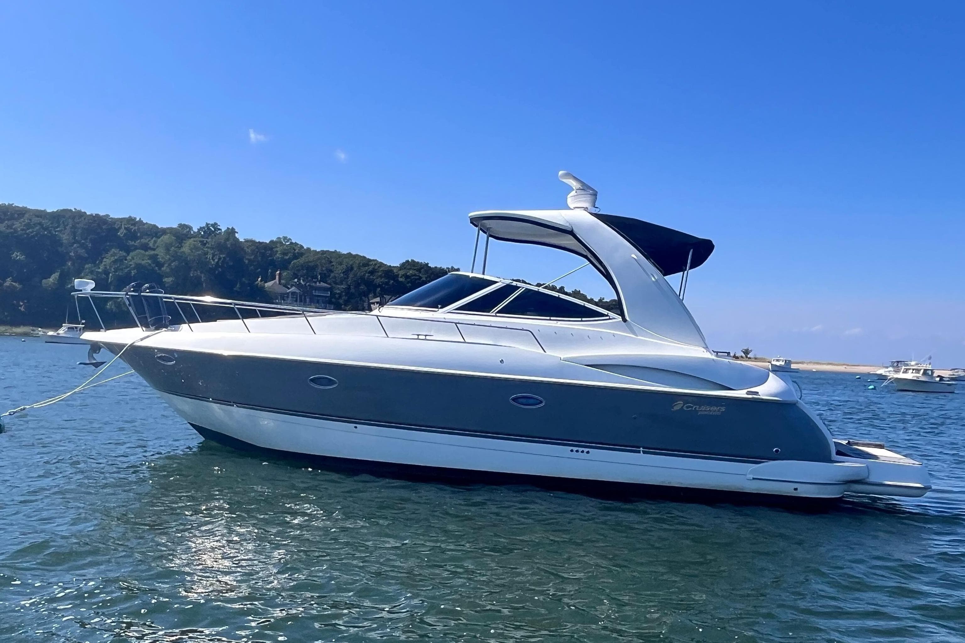 2007 Cruisers Yachts 370 Express on calm water, clear sky background.