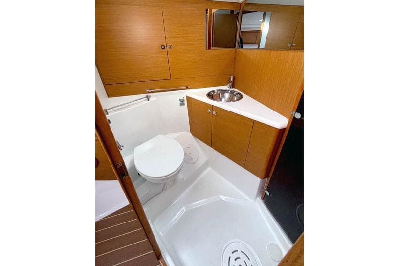 Bathroom interior of 2016 Jeanneau Sun Odyssey 50 DS yacht, featuring wood cabinetry and modern fixtures.