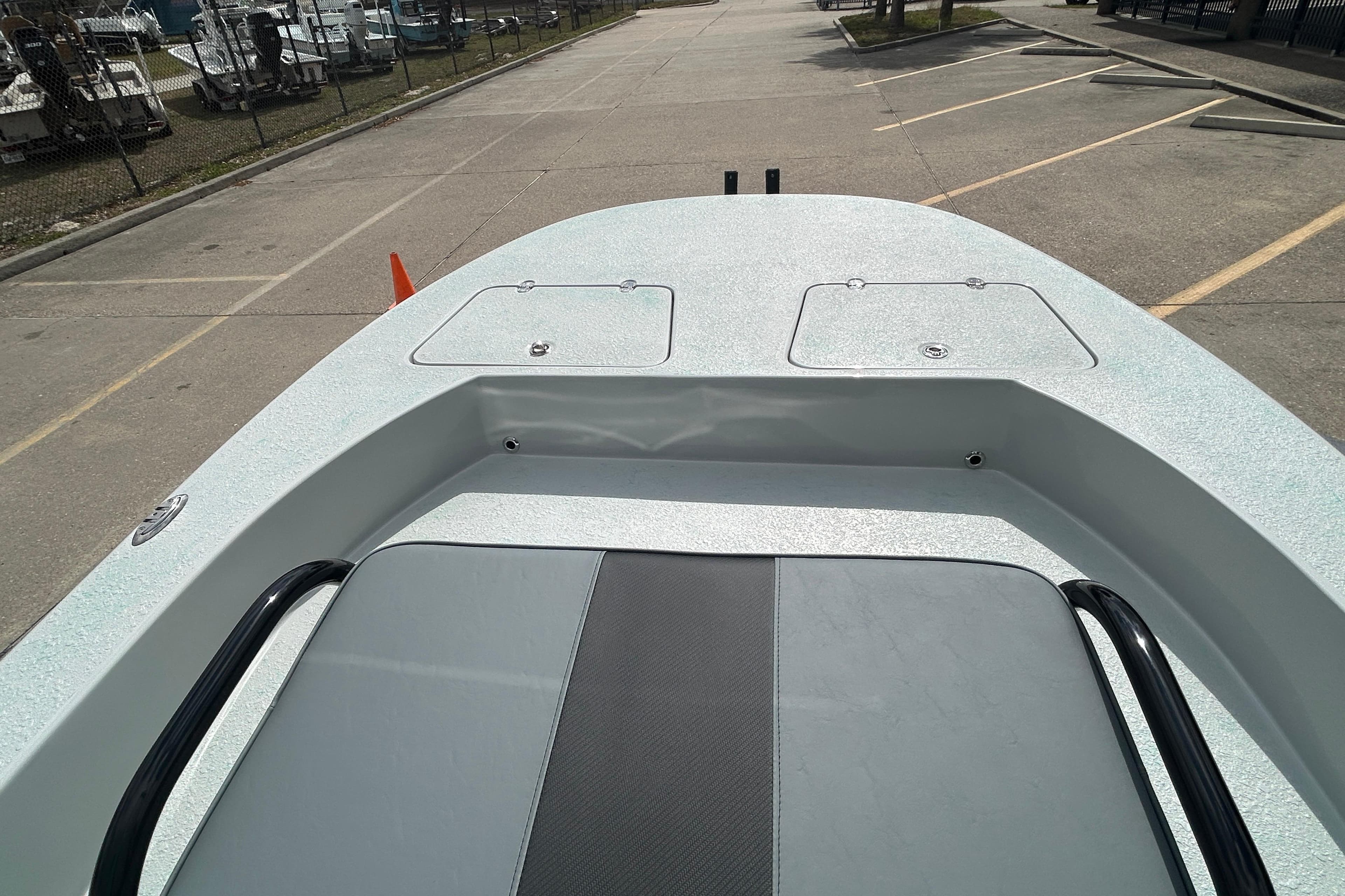 2026 Gulf Coast Saber Cat boat deck in a parking lot, showcasing storage compartments.