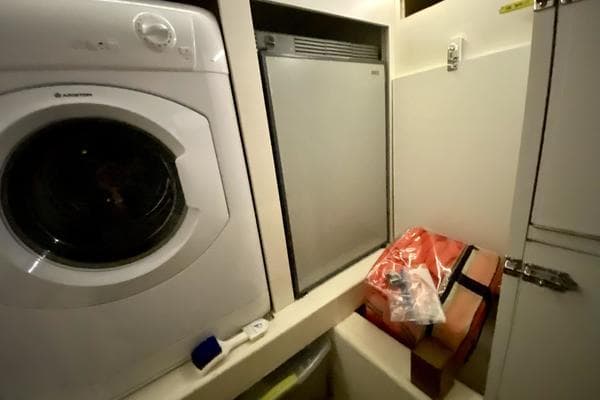 Laundry area on 2011 Grand Banks 46 Eastbay SX with washer and storage.