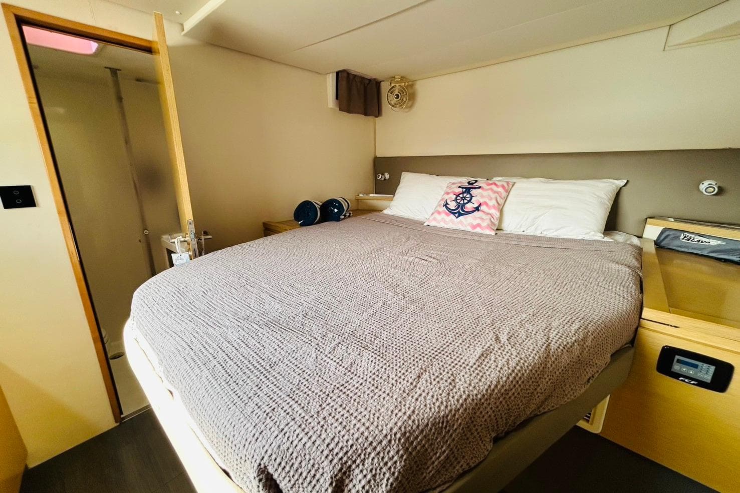 Cozy bedroom in 2015 Fountaine Pajot SABA50 yacht with nautical-themed decor.