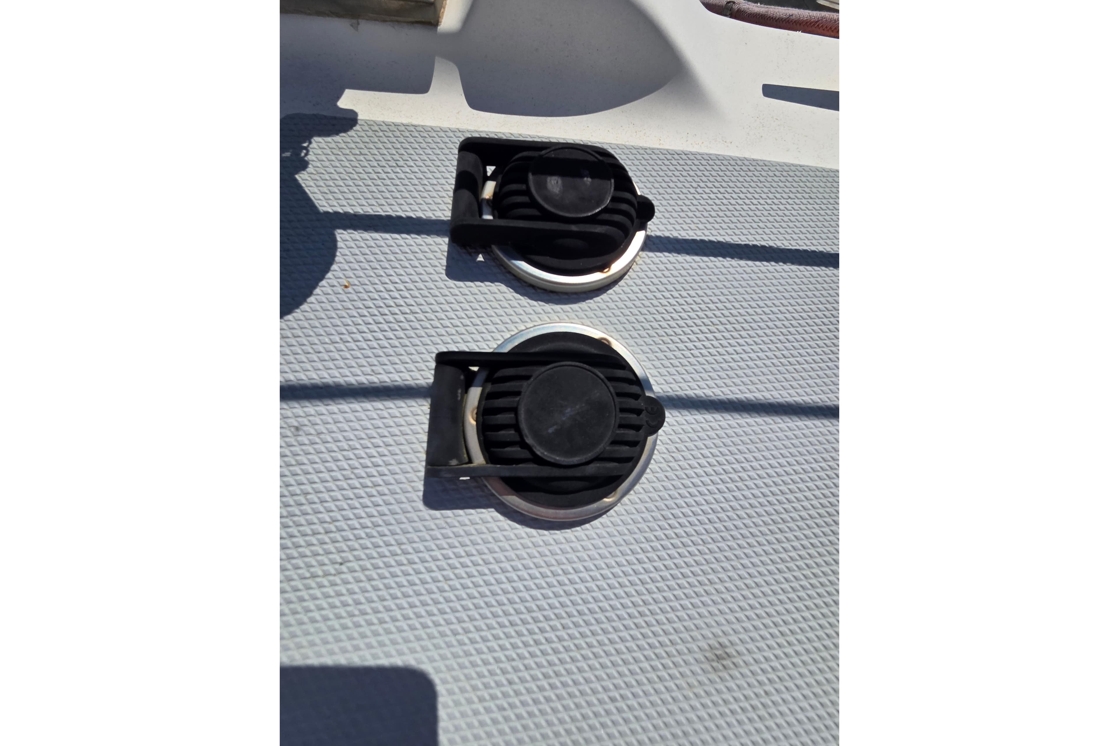 Deck fittings on a 2005 Hunter 31 sailboat, featuring textured surface and black covers.