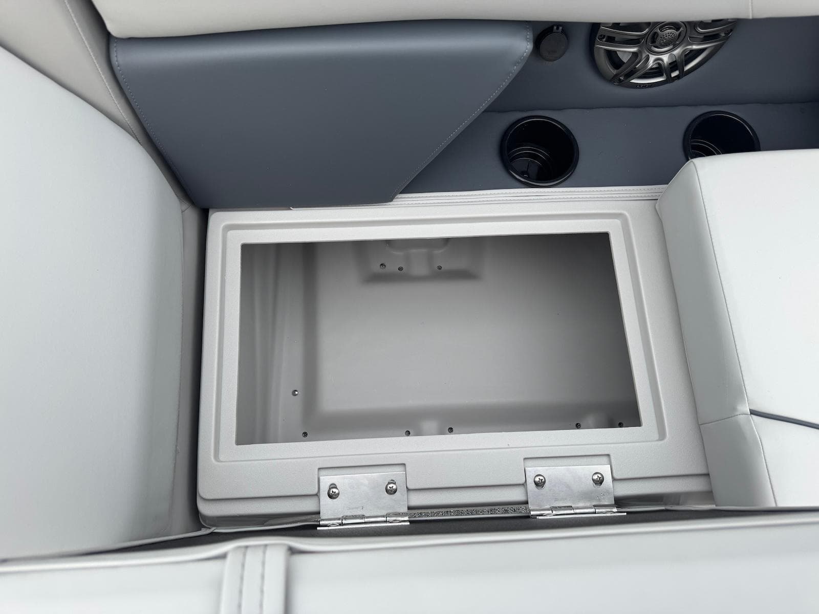 Storage compartment in 2025 Godfrey Sweetwater 2086 SB boat, featuring cup holders and speaker.