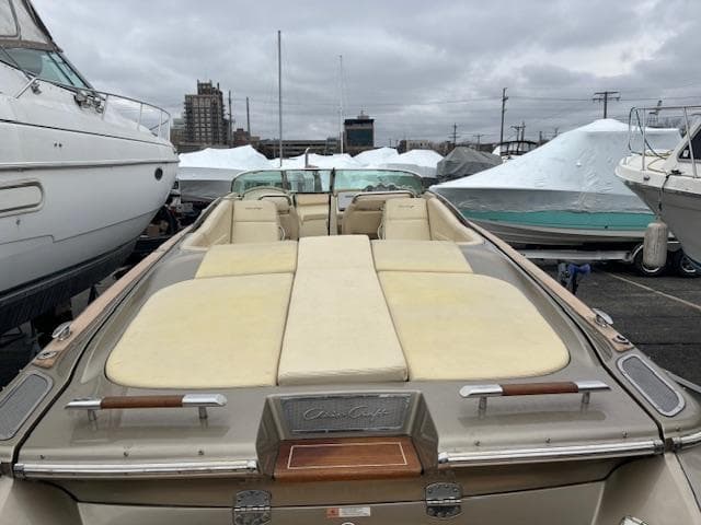 2014 Chris-Craft Launch 32 boat with beige seating, docked in a marina.