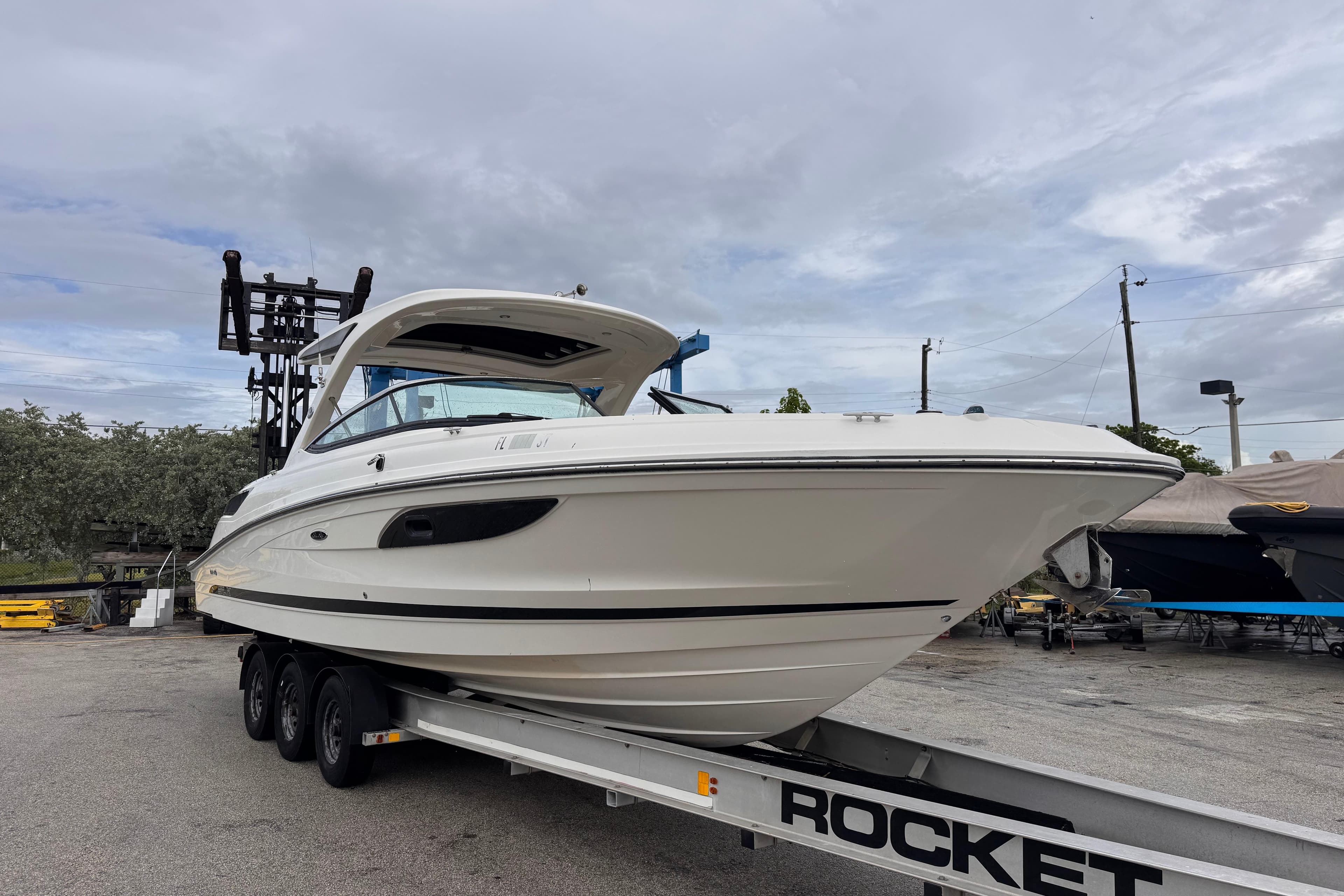 2016 Sea Ray SLX 350 boat on trailer under cloudy sky.