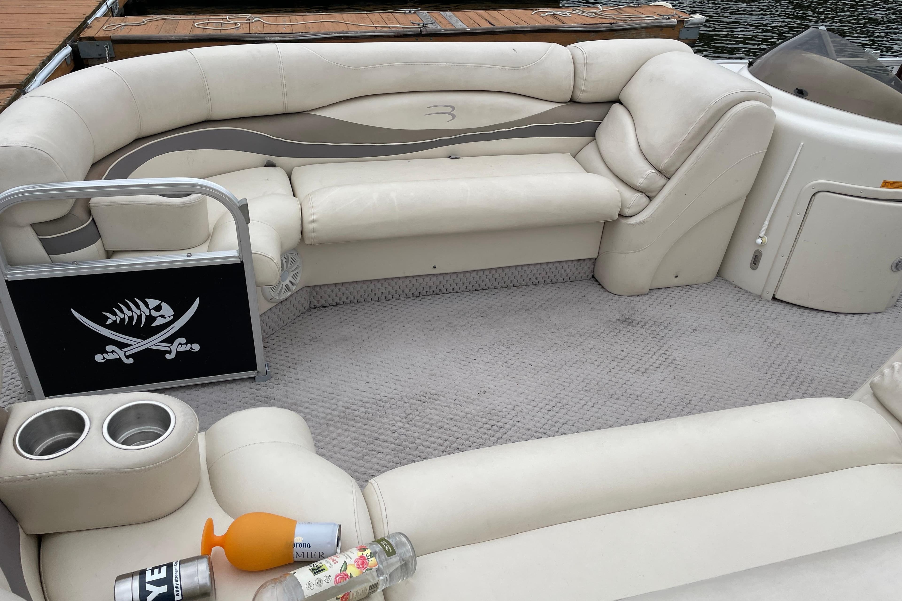 2005 Bennington 2275RL boat interior with white seating and pirate-themed decor.