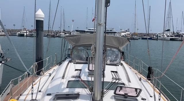 2010 Beneteau Oceanis 46 sailboat docked in a marina, surrounded by other boats.