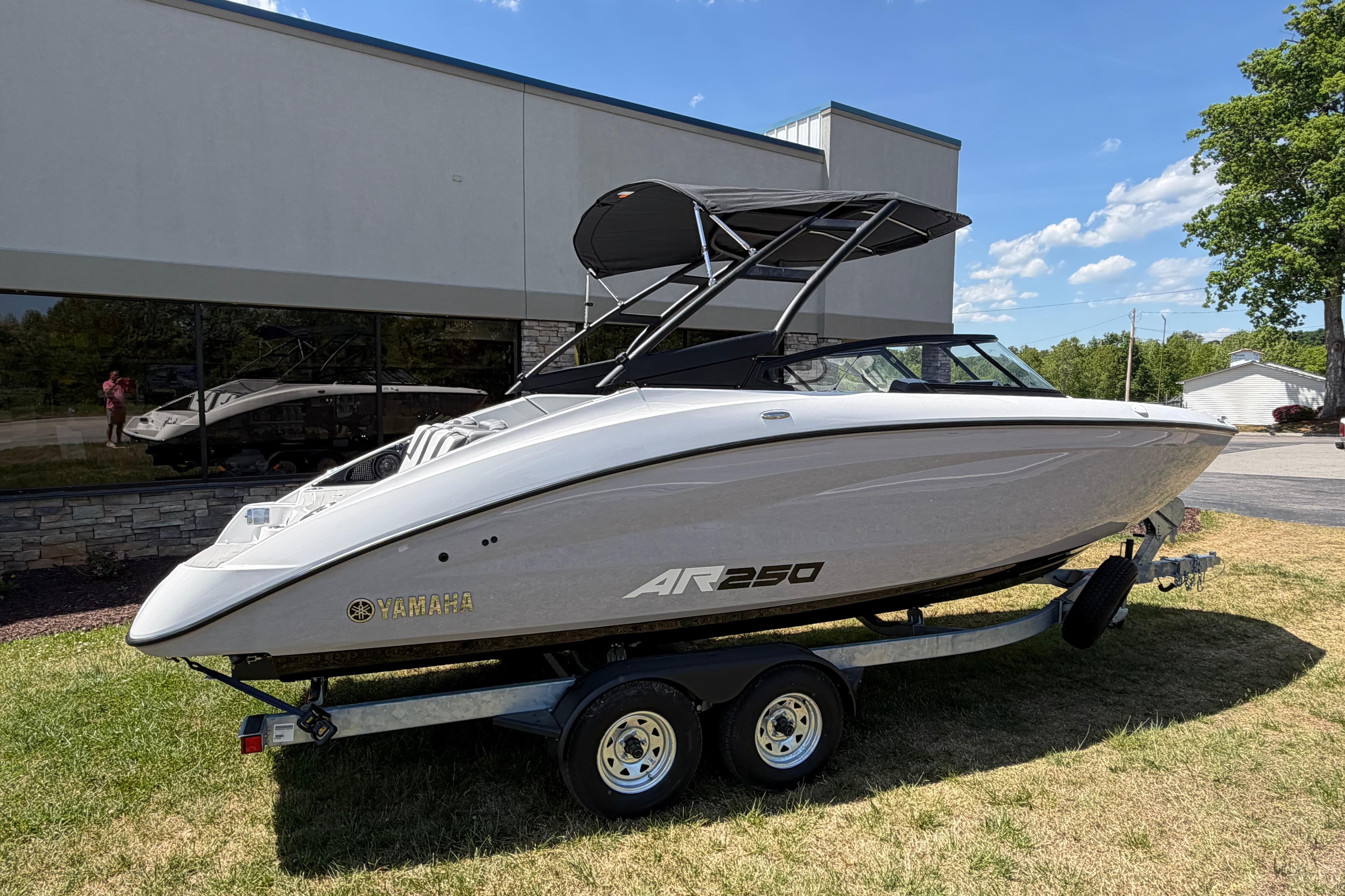 2026 Yamaha AR250 boat on trailer, parked outdoors under clear blue sky.