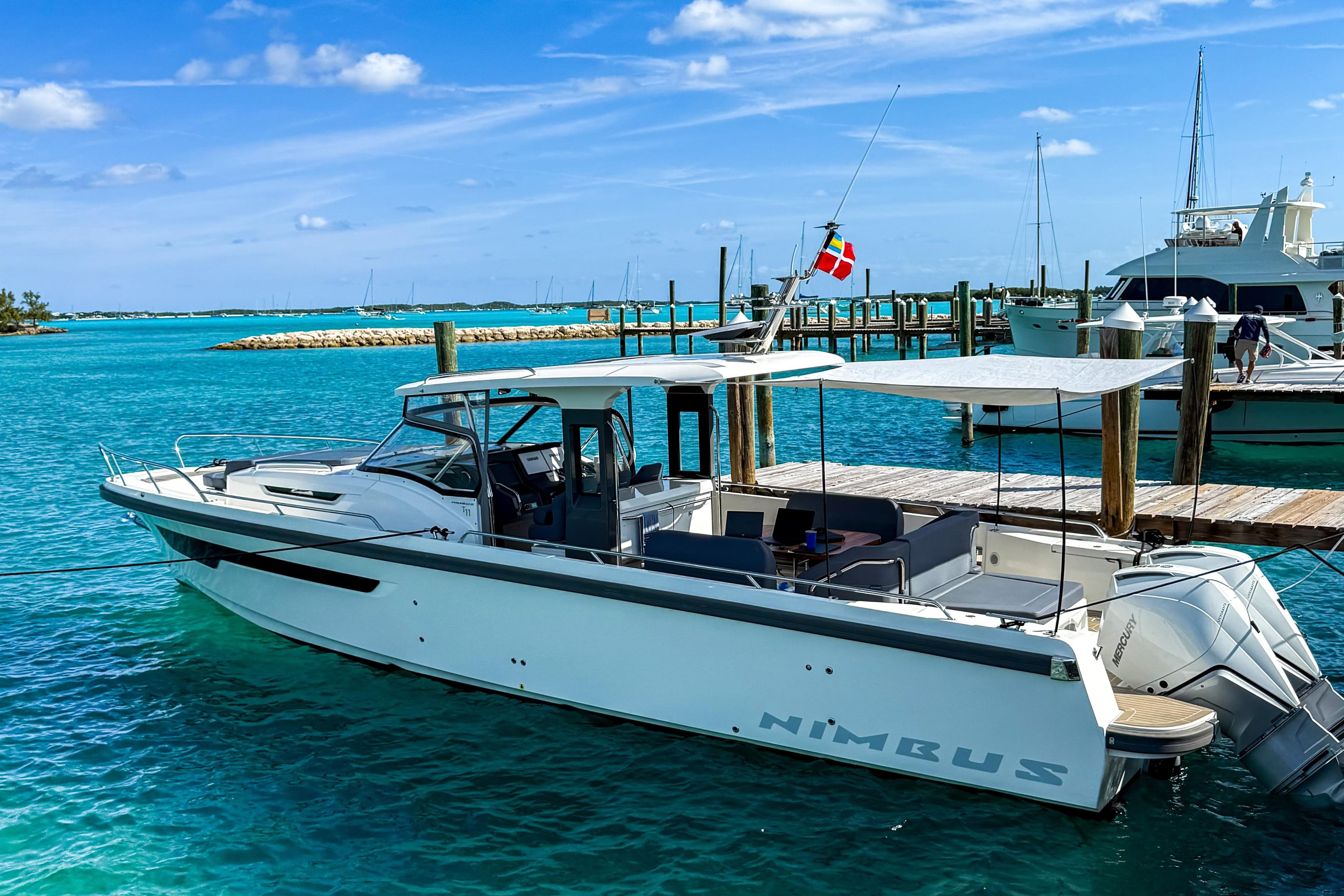 2022 Nimbus T11 boat docked in clear turquoise water under a sunny sky.