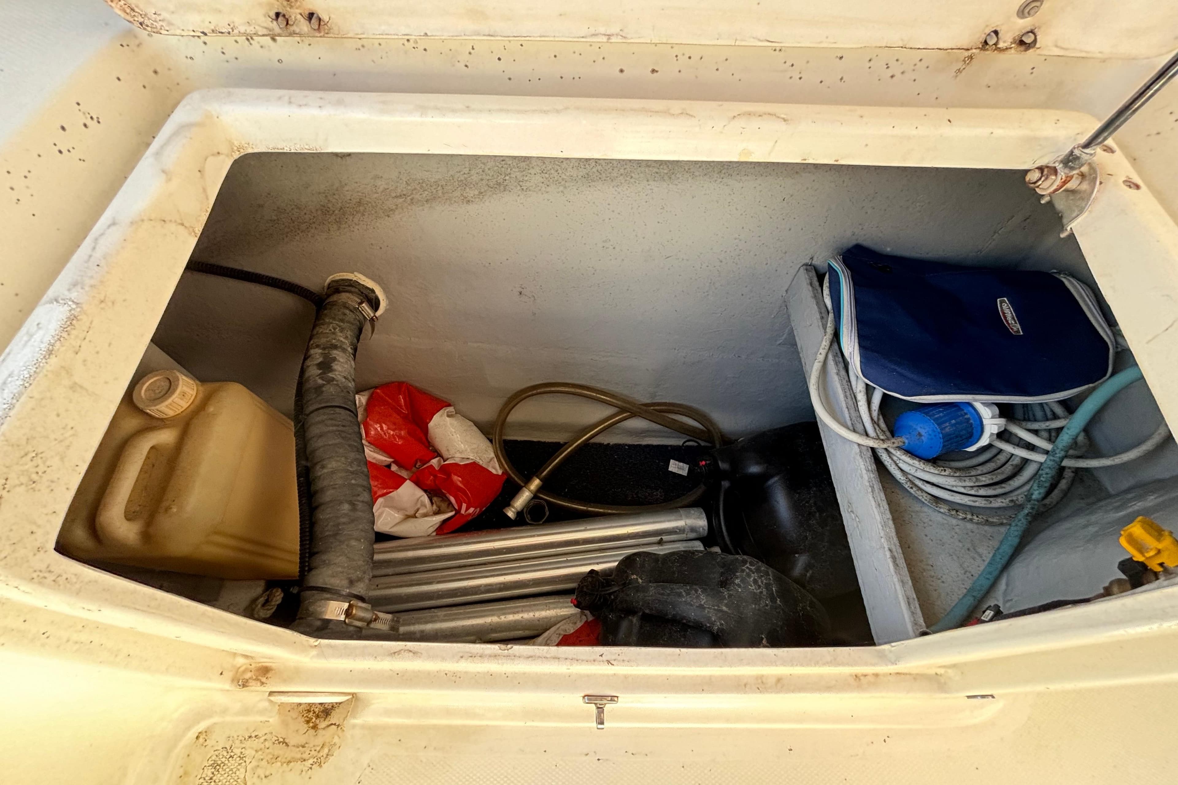 Storage compartment of a 2016 Saver 300 boat with various equipment and supplies.