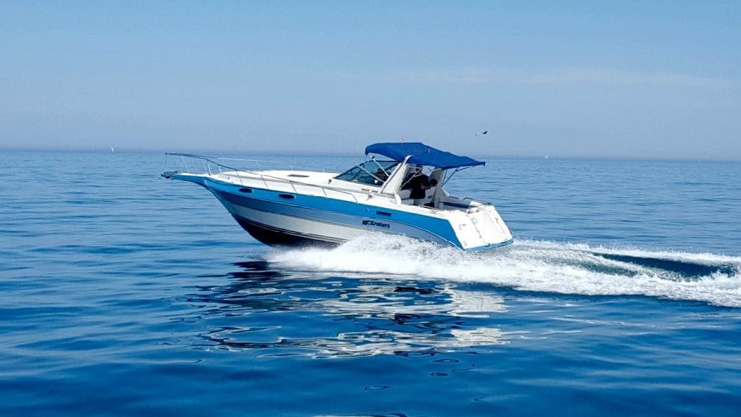 1989 Cruisers Yachts 3060 Rogue cruising on calm blue waters.