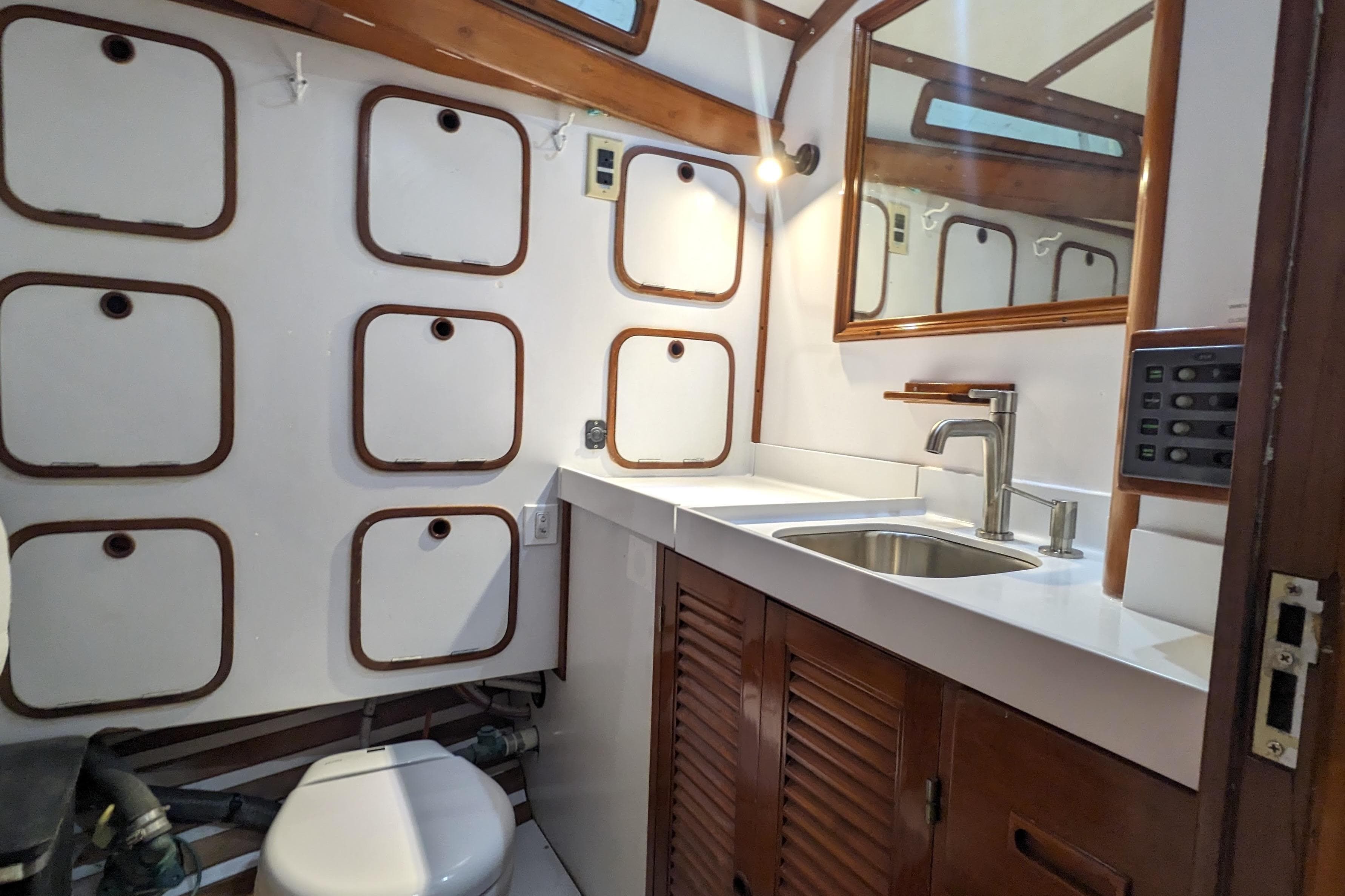 Bathroom interior of 1984 Tayana Vancouver 42 yacht with sink and storage cabinets.