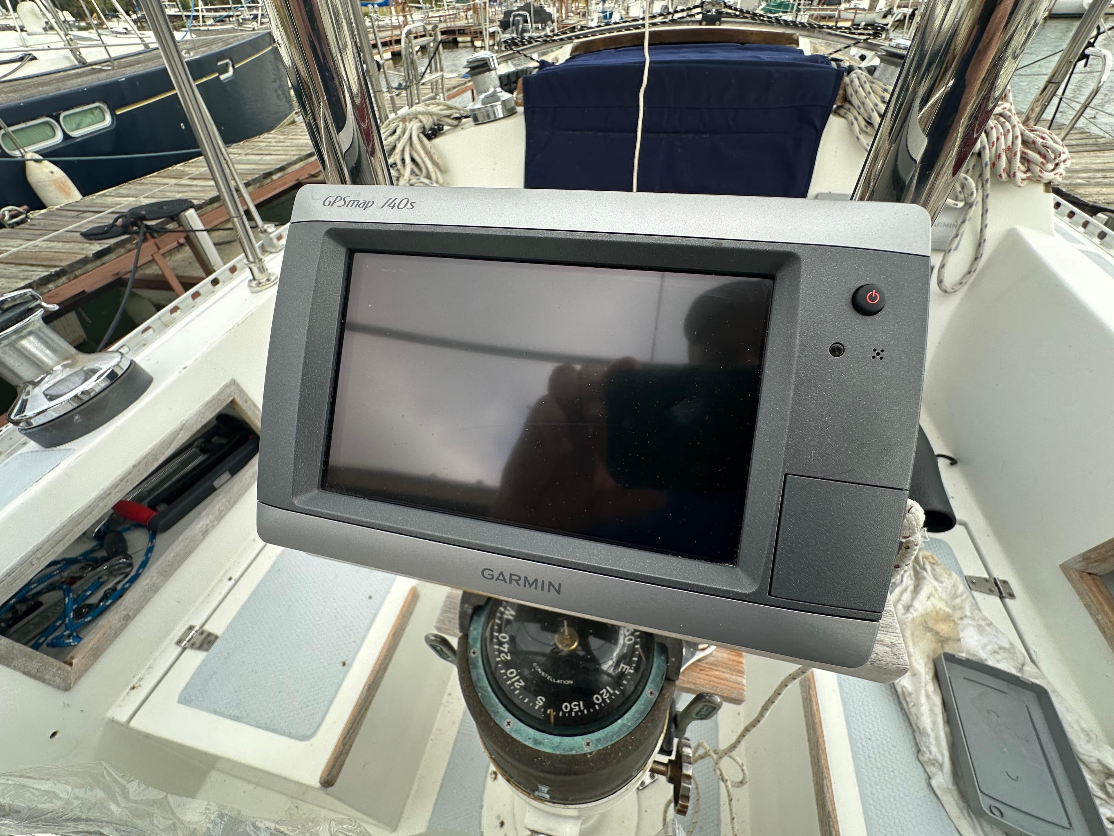Garmin GPS on 1979 Valiant 37 sailboat cockpit, marina background.