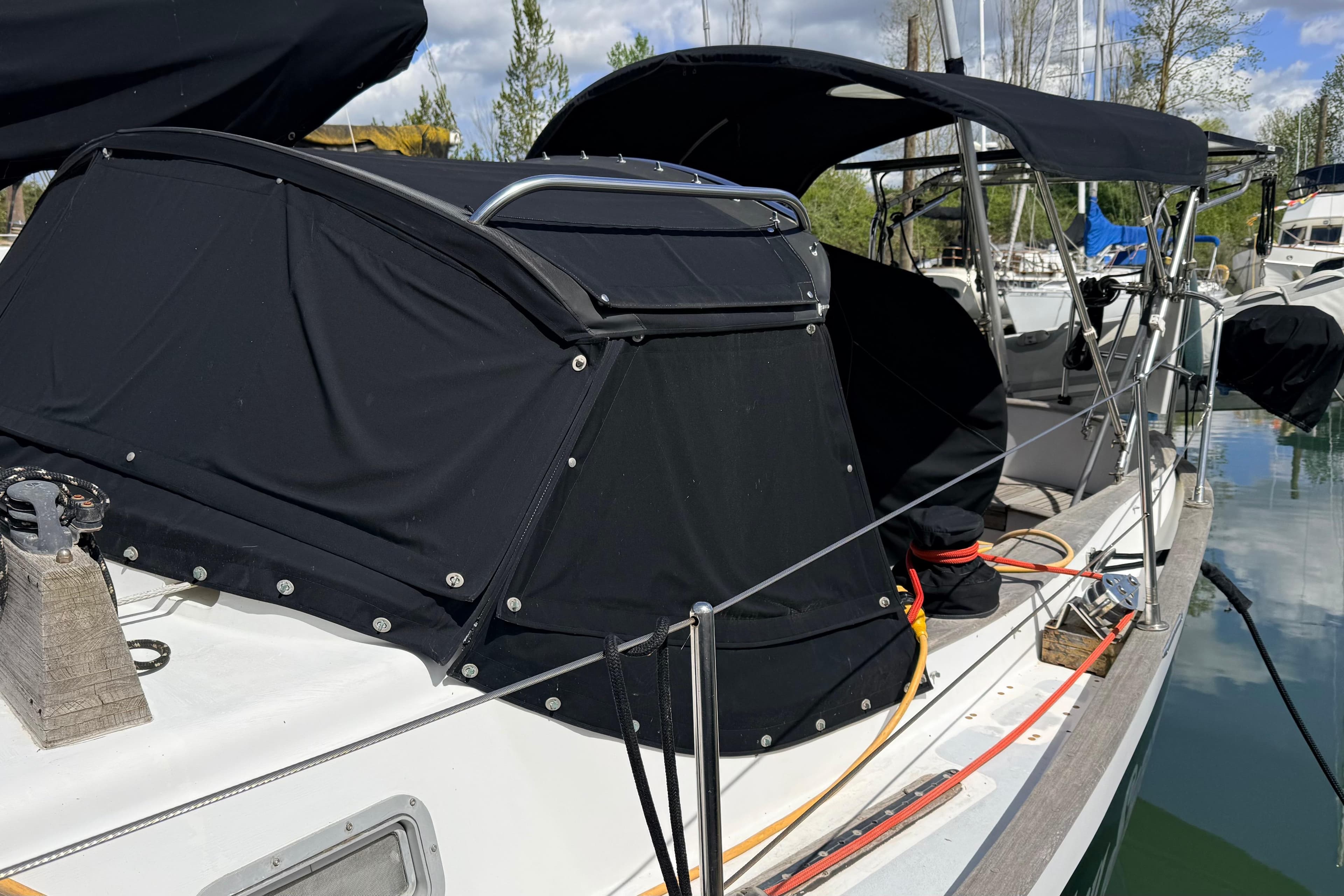 1983 Tanton 44 sailboat with black canvas cover docked at marina.