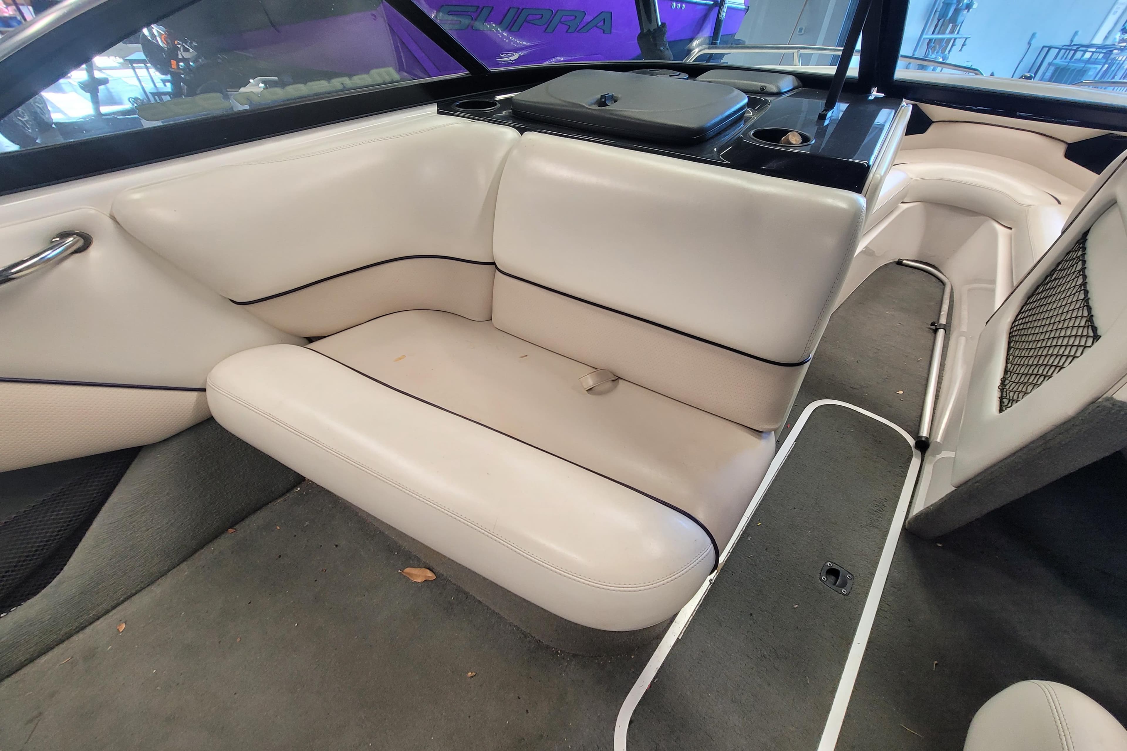 2003 Malibu Sunsetter LXi boat interior with white leather seating and carpeted floor.
