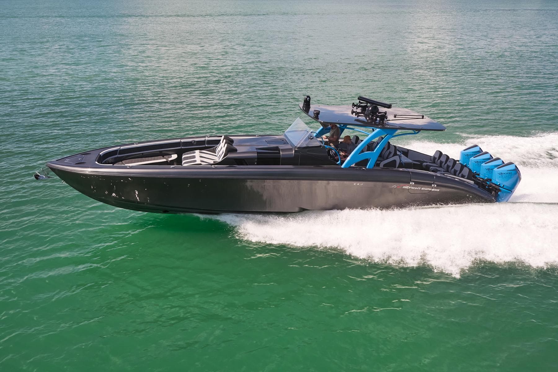 2023 Midnight Express 43' Solstice speedboat cruising on clear green water.